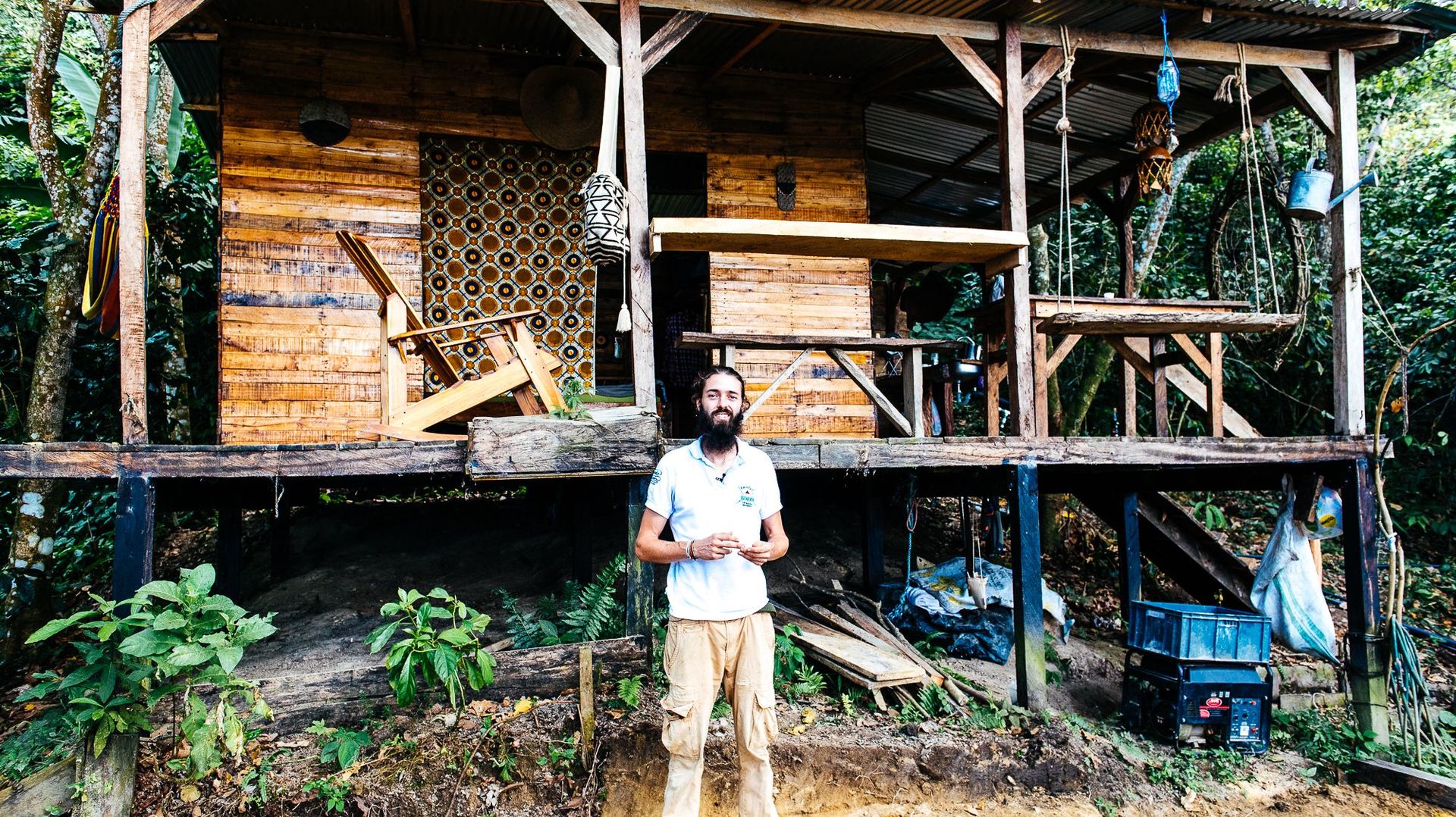 Philippe devant sa magnifique cabane construite en quelques semaines avec les matériaux donnés par la forêt.  