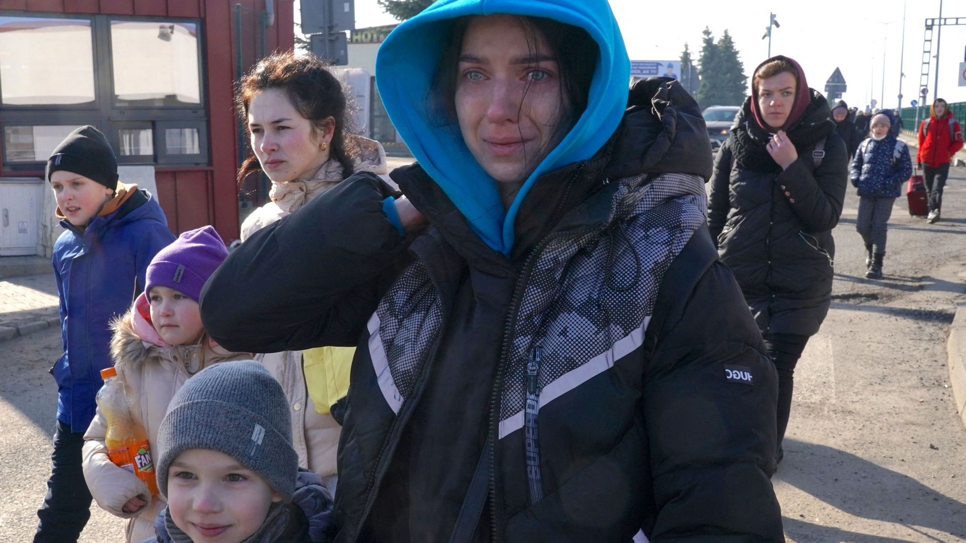 Des femmes et des enfants ukrainien·nes traversent la frontière entre l'Ukraine et la Pologne au poste frontière de Korczowa-Krakovets.