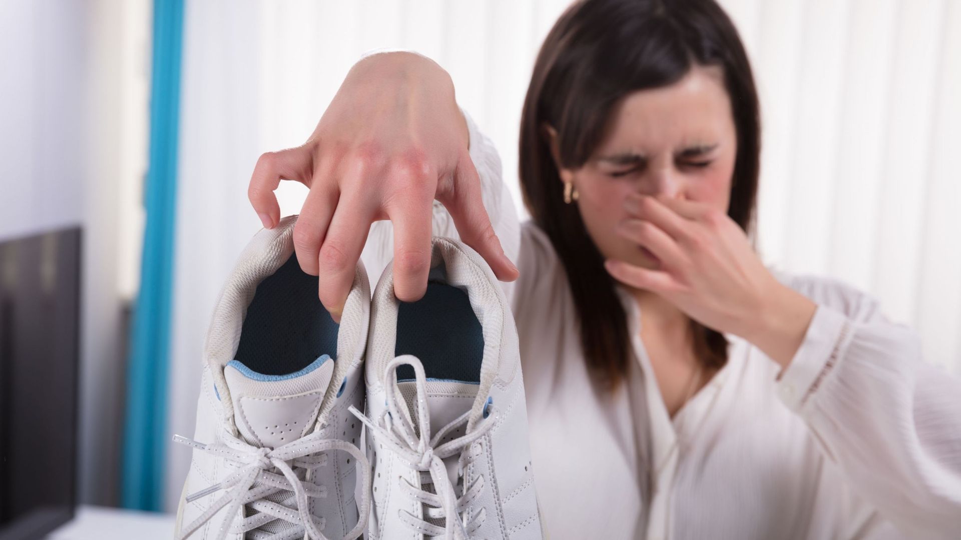 Woman Holding Dirty Smelling Shoes