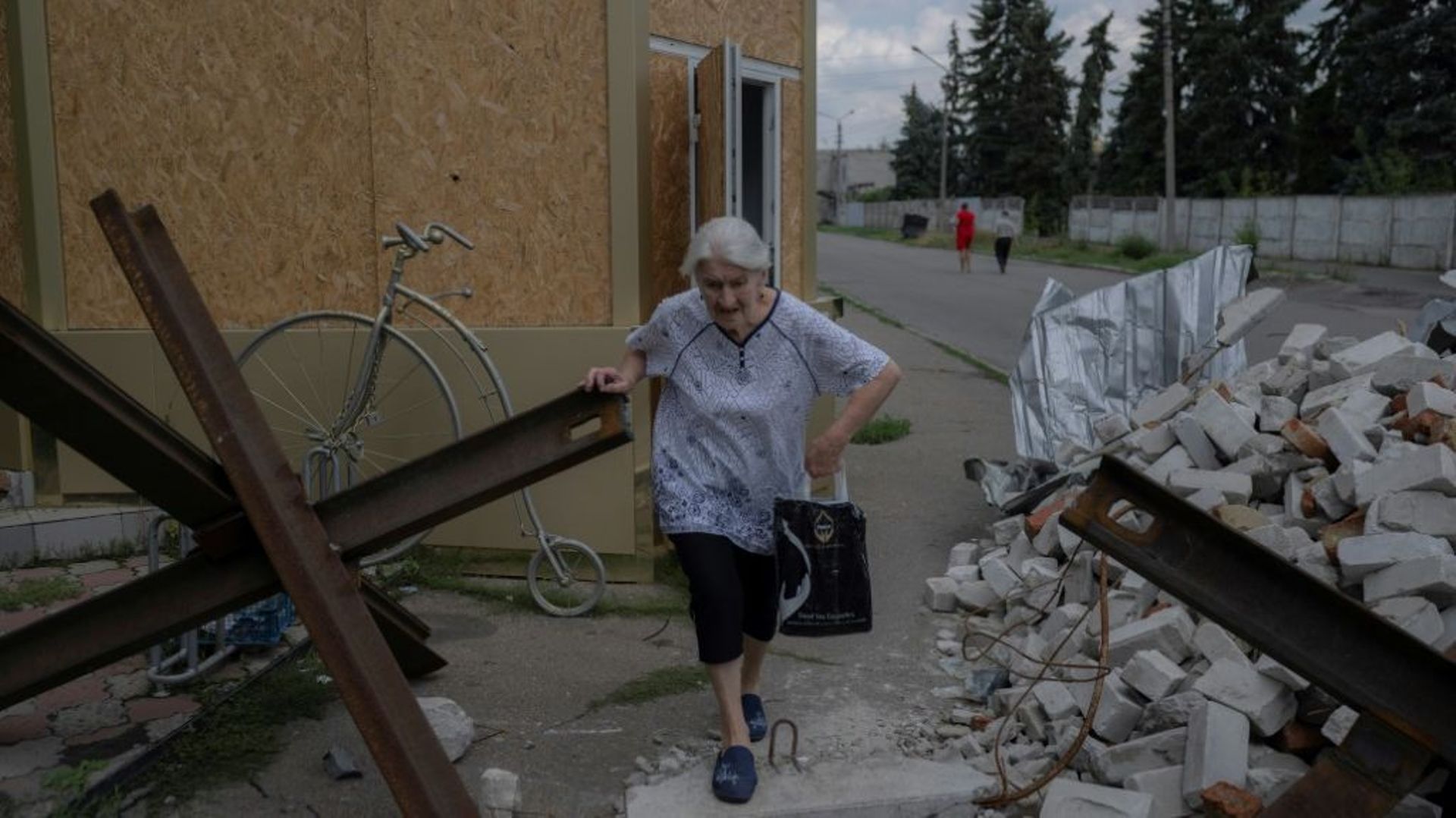 Une femme âgée traverse un barrage routier à Bakhmout, dans l’est de l’Ukraine, le 4 août 2022