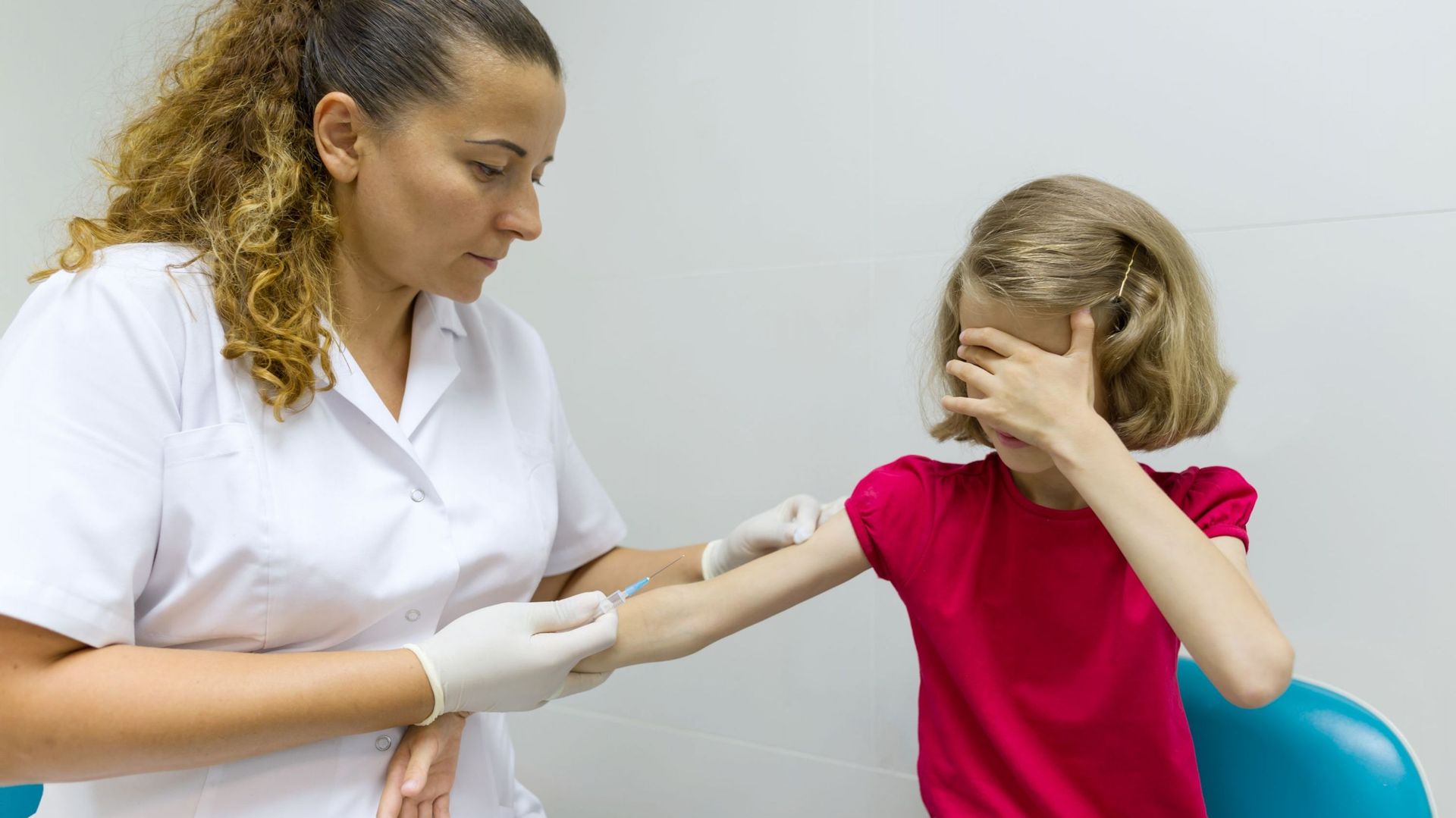 Infirmière inocule vaccin à une fillette.