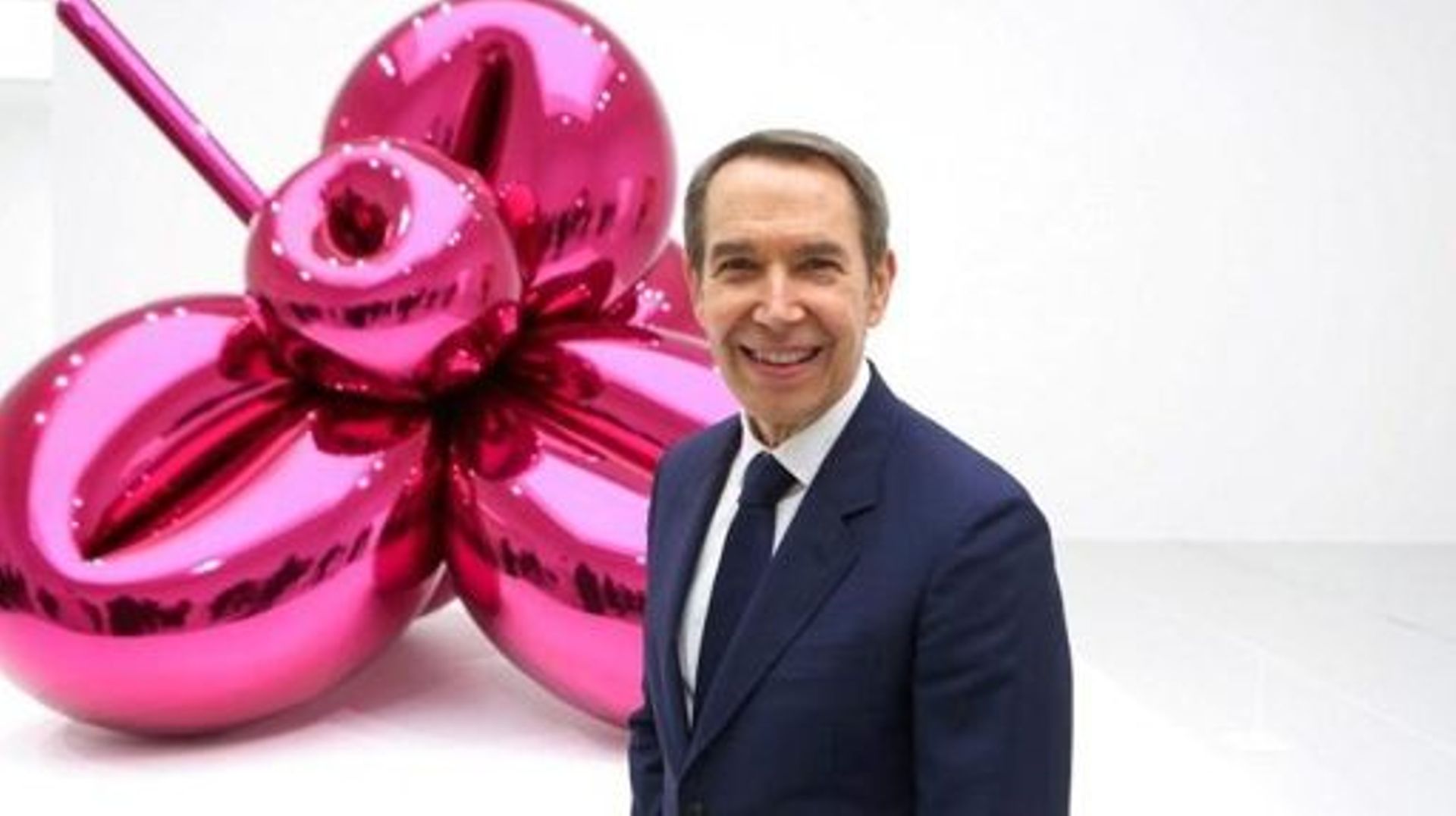 US artist Jeff Koons poses in front of his Balloon Flower exhibited at the Qatar Museum Alriwaq gallery in Doha on November 20, 2021. Curated by Massimiliano Gioni, the exhibition provides a unique view into the exceptional career of one of the world?s be