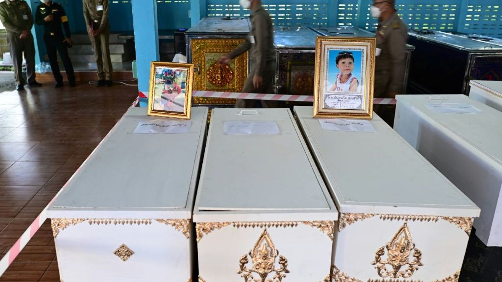 Des portraits de jeunes victimes d’un massacre dans une crèche posés sur leurs cercueils dans le temple de Wat Si Uthai, dans la province thaïlandaise de Nong Bua Lamphu le 7 octobre 2022.