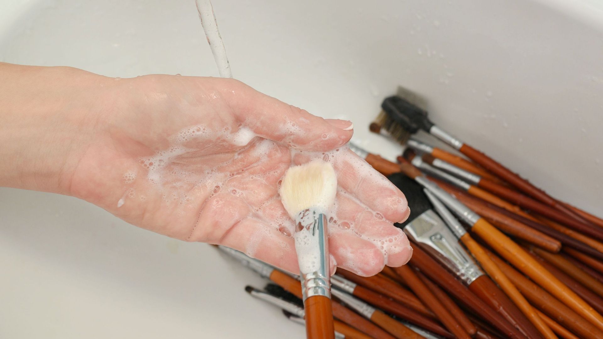 Lavage de pinceaux au savon dans un évier
