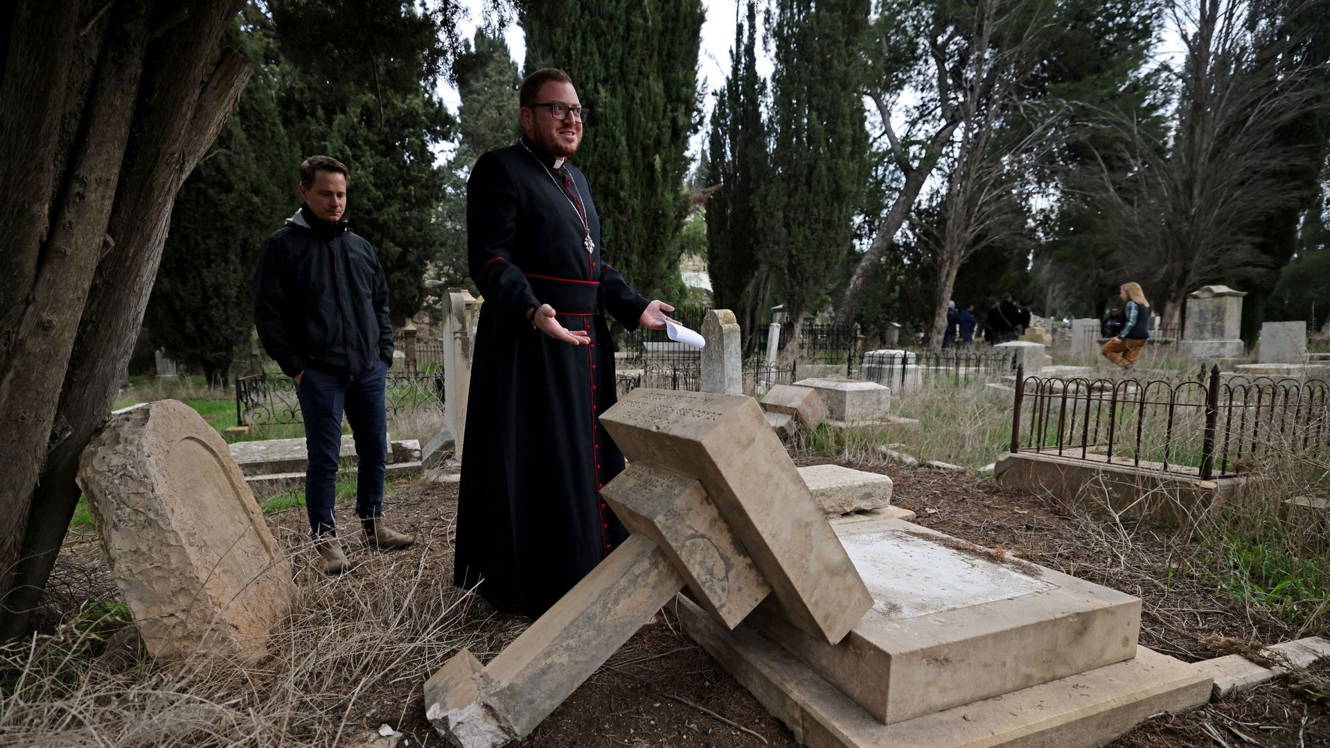 Hosam Naoum, archevêque et gardien du cimetière protestant, inspecte des tombes vandalisées sur le Mont Sion, à l'extérieur de la vieille ville de Jérusalem, le 4 janvier 2023.