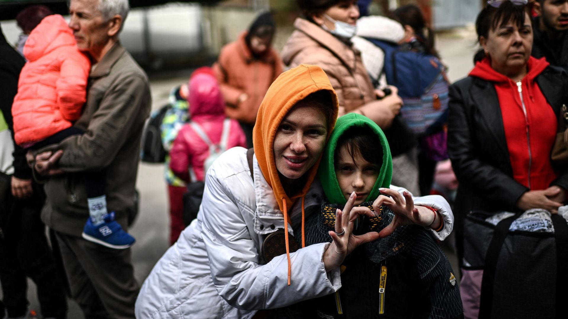 Une réfugiée ukrainienne fait un signe d'amour alors qu'elle attend de monter dans un bus avec son fils en direction de l'Allemagne dans la capitale moldave Chisinau, le 13 avril (illustration).