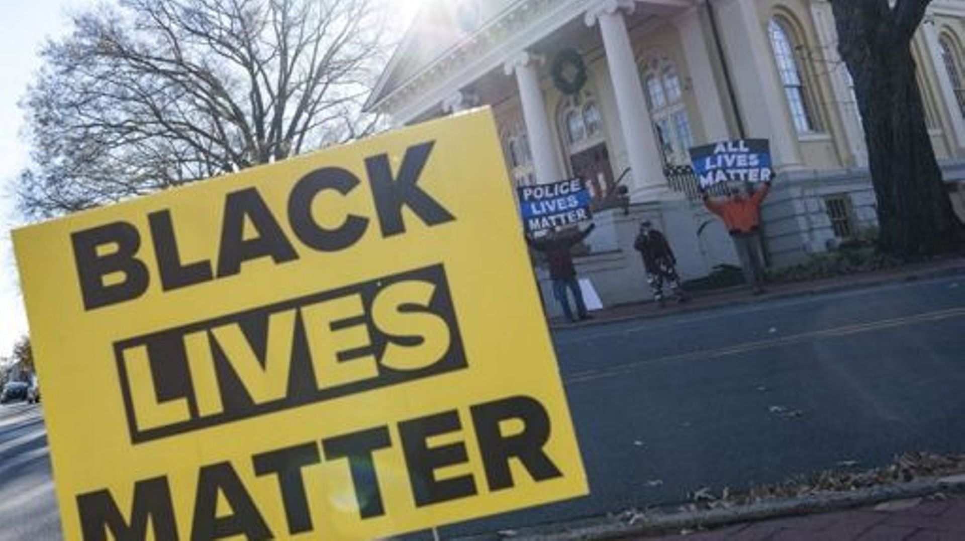 Des manifestants tenant des pancartes de protestation sur lesquelles on peut lire "Police Lives Matter" et "All Lives Matter" manifestent en face d'une manifestation "Black Lives Matter" sur la place de la ville à Warrenton, en Virginie, le 27 novembre 20