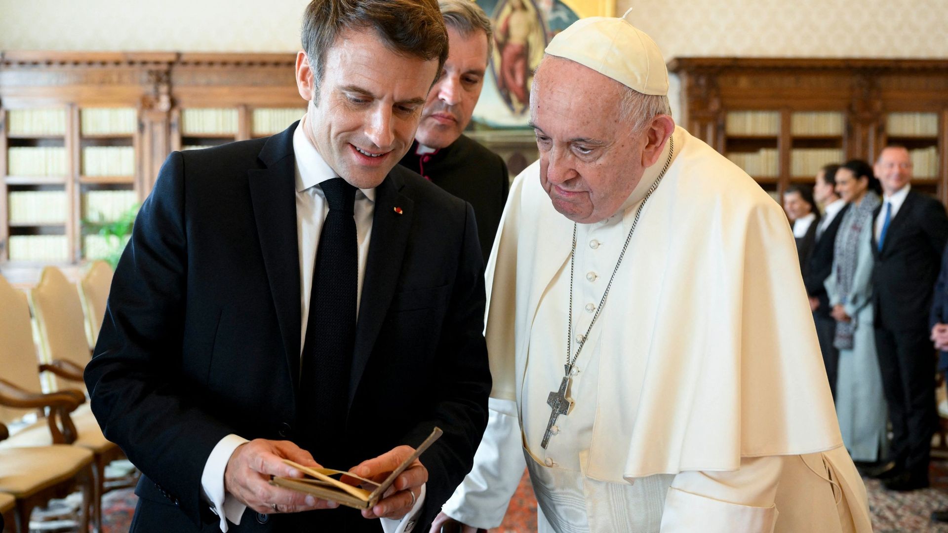 Cette photo publiée le 24 octobre 2022 par le bureau de presse du Vatican montre le pape François échangeant des cadeaux avec le président français Emmanuel Macron lors d’une audience privée au Vatican. Macron a donné à François un exemplaire de la premiè