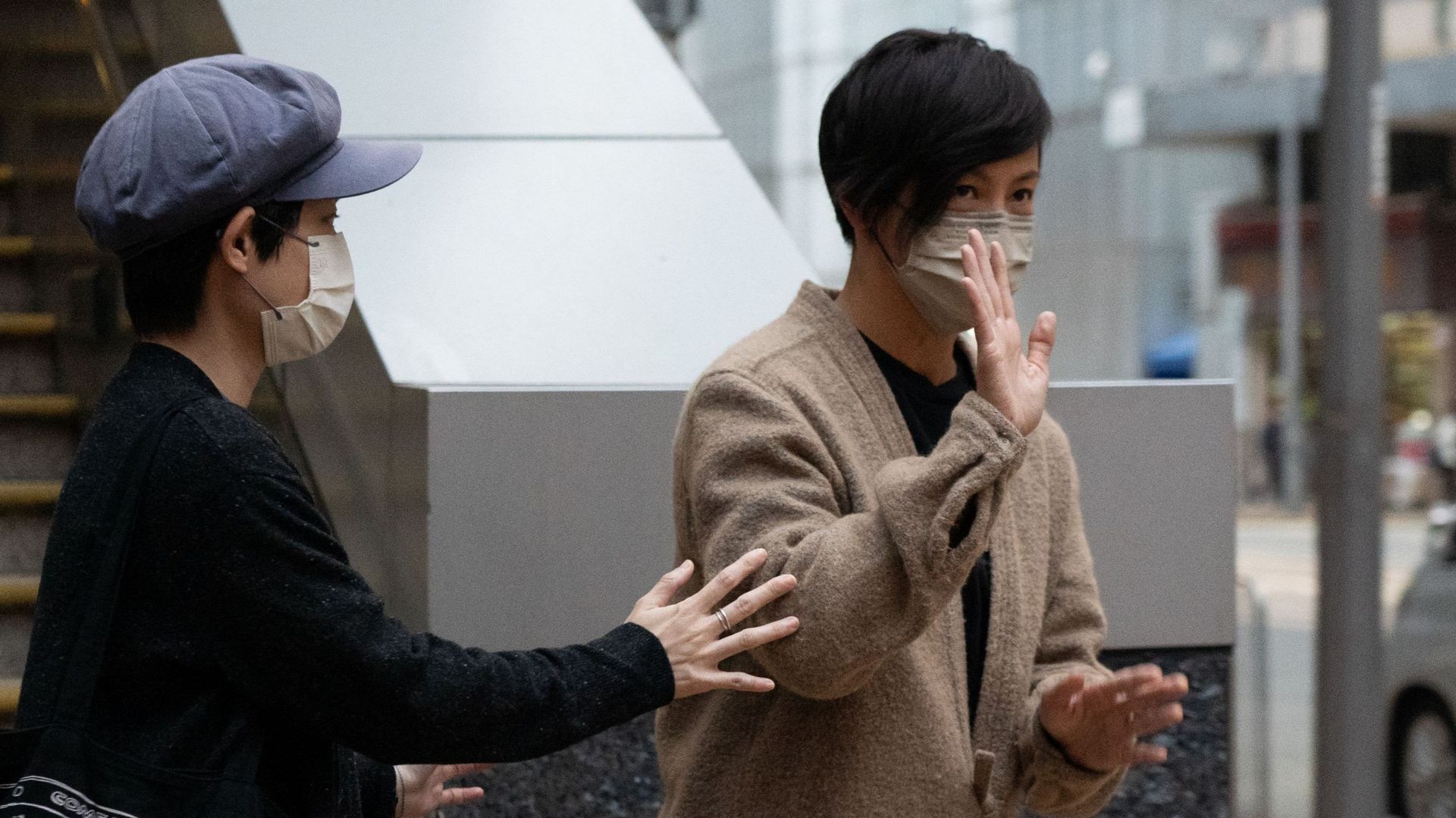 Pro-democracy activist and singer Denise Ho (R), a former board member of Stand News, leaves the Western Police Station after being released from custody in Hong Kong on December 30, 2021, following her arrest 