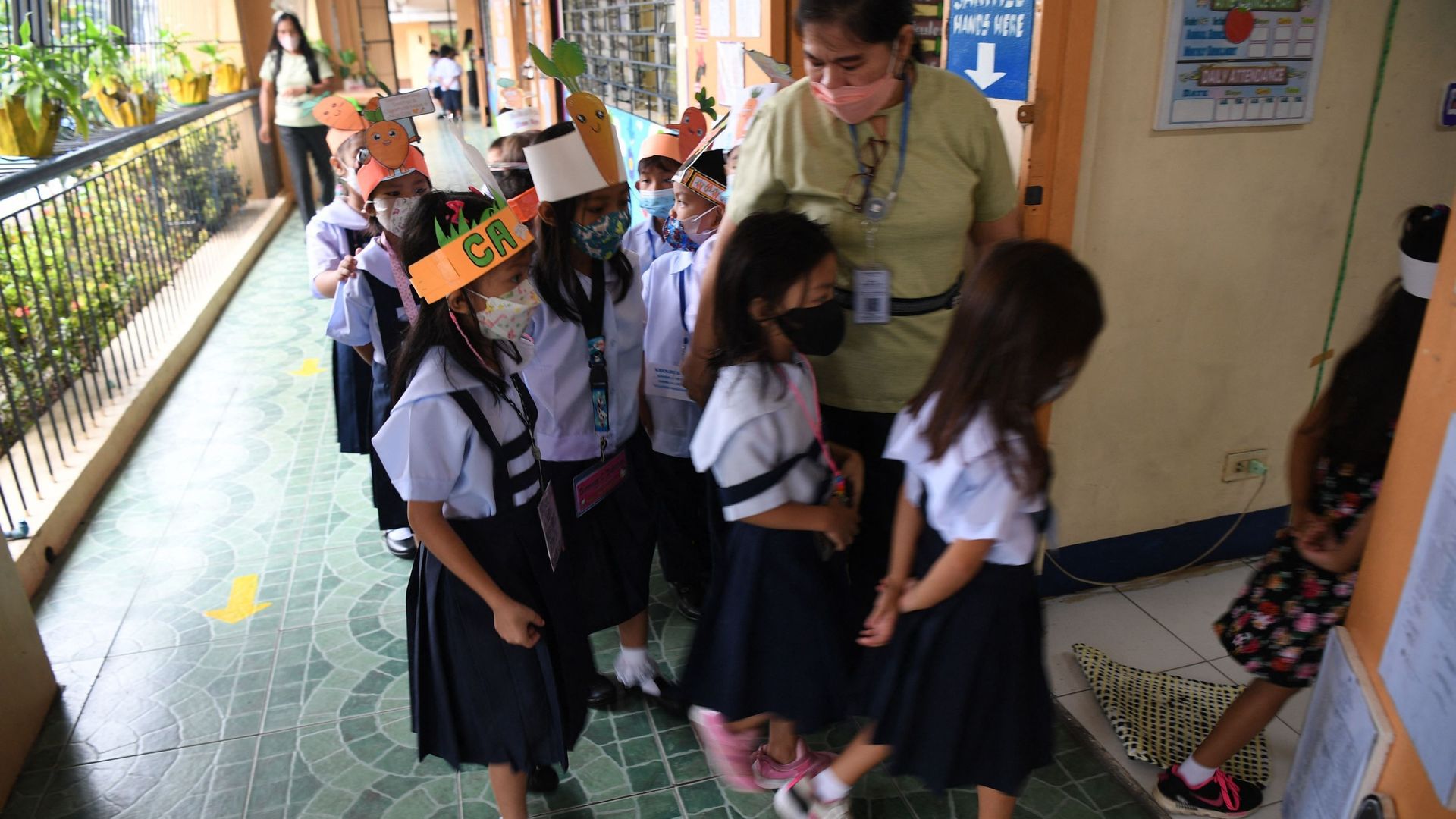 Les écoliers entrent en classe dans une école de Quezon City, dans la banlieue de Manille, le 22 août 2022.