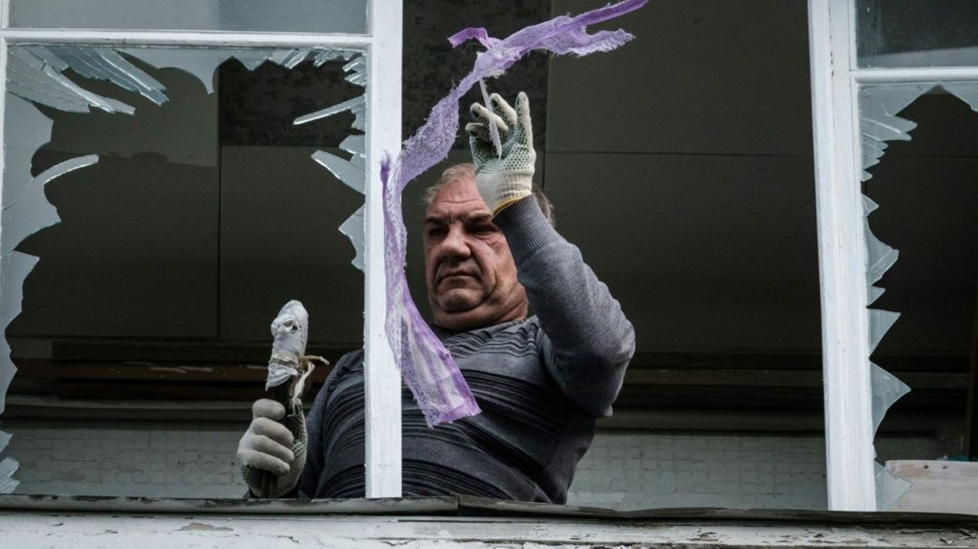 Un habitant de Kharkiv nettoie les débris de fenêtres soufflées par des explosions, le 21 septembre 2022.