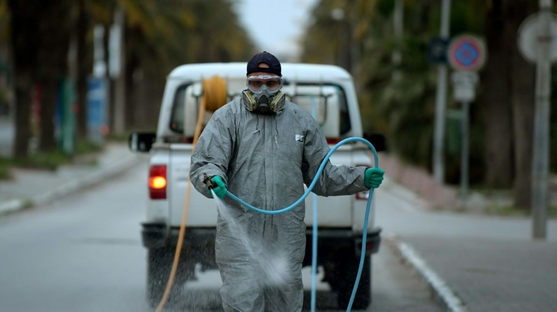 Un employé municipal désinfecte une rue pendant l'épidémie de coronavirus, le 1er avril 2020 à Tunis