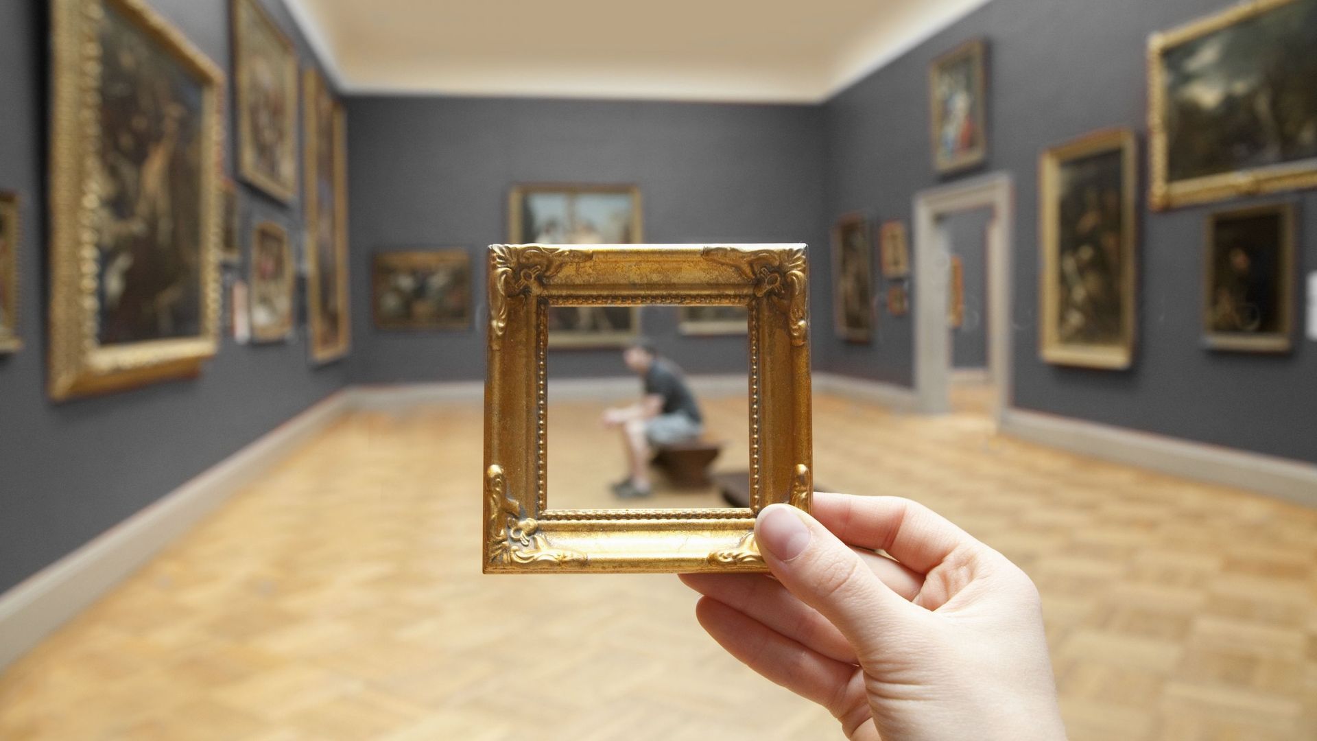 Personne tenant un cadre miniature dans un musée 