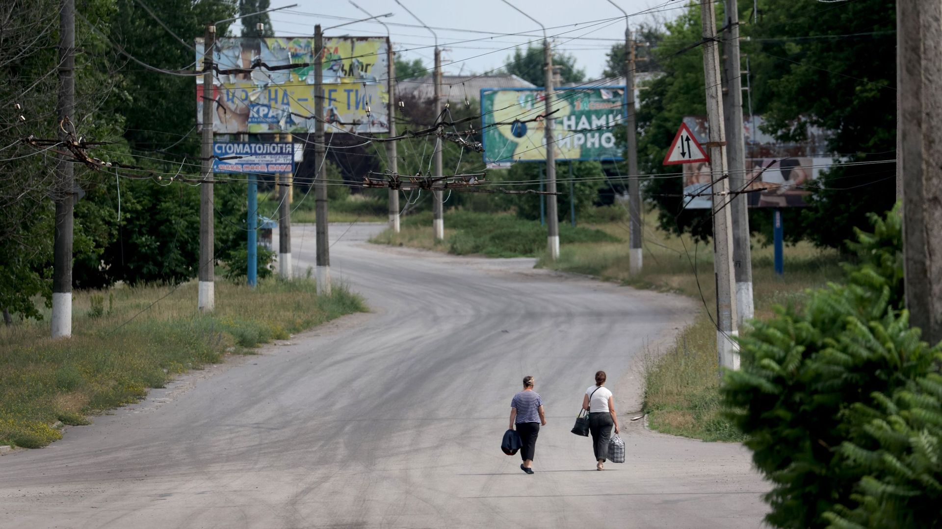 des femmes marchent dans une rue vide le 16 juin 2022 à Lyssychansk, en Ukraine.