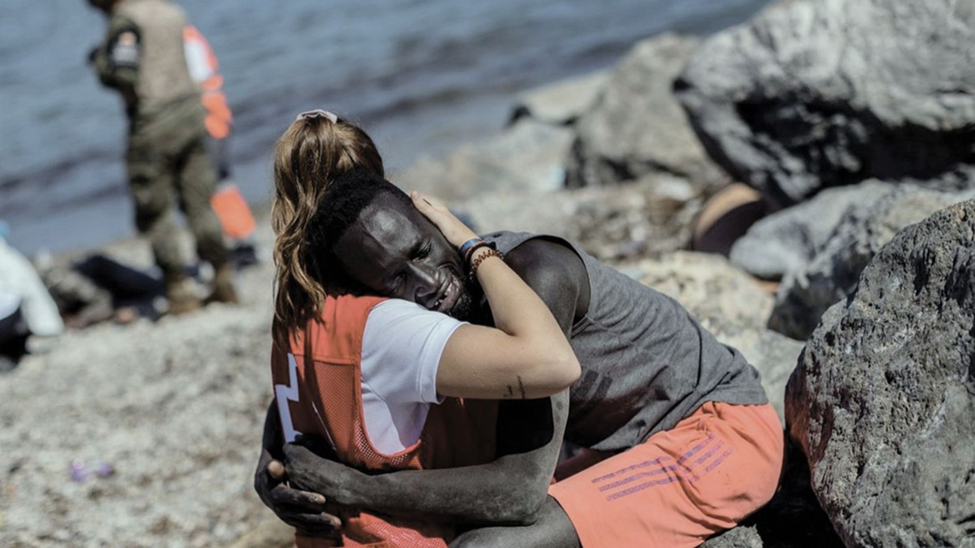 Un migrant à Ceuta est réconforté par une volontaire. Une photo de Bernat Armangué -2021