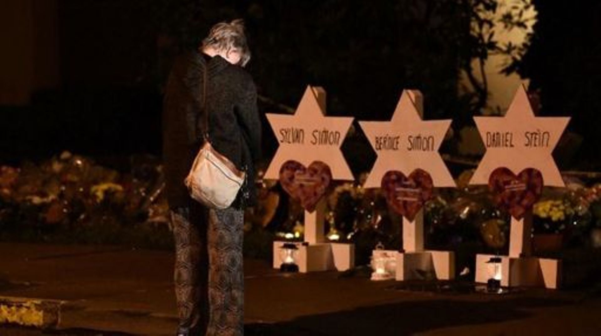 A woman bows her head in front of a memorial on October 28, 2018, at the Tree of Life synagogue after a shooting there left 11 people dead in the Squirrel Hill neighborhood of Pittsburgh on October 27. A man suspected of bursting into a Pittsburgh synagog