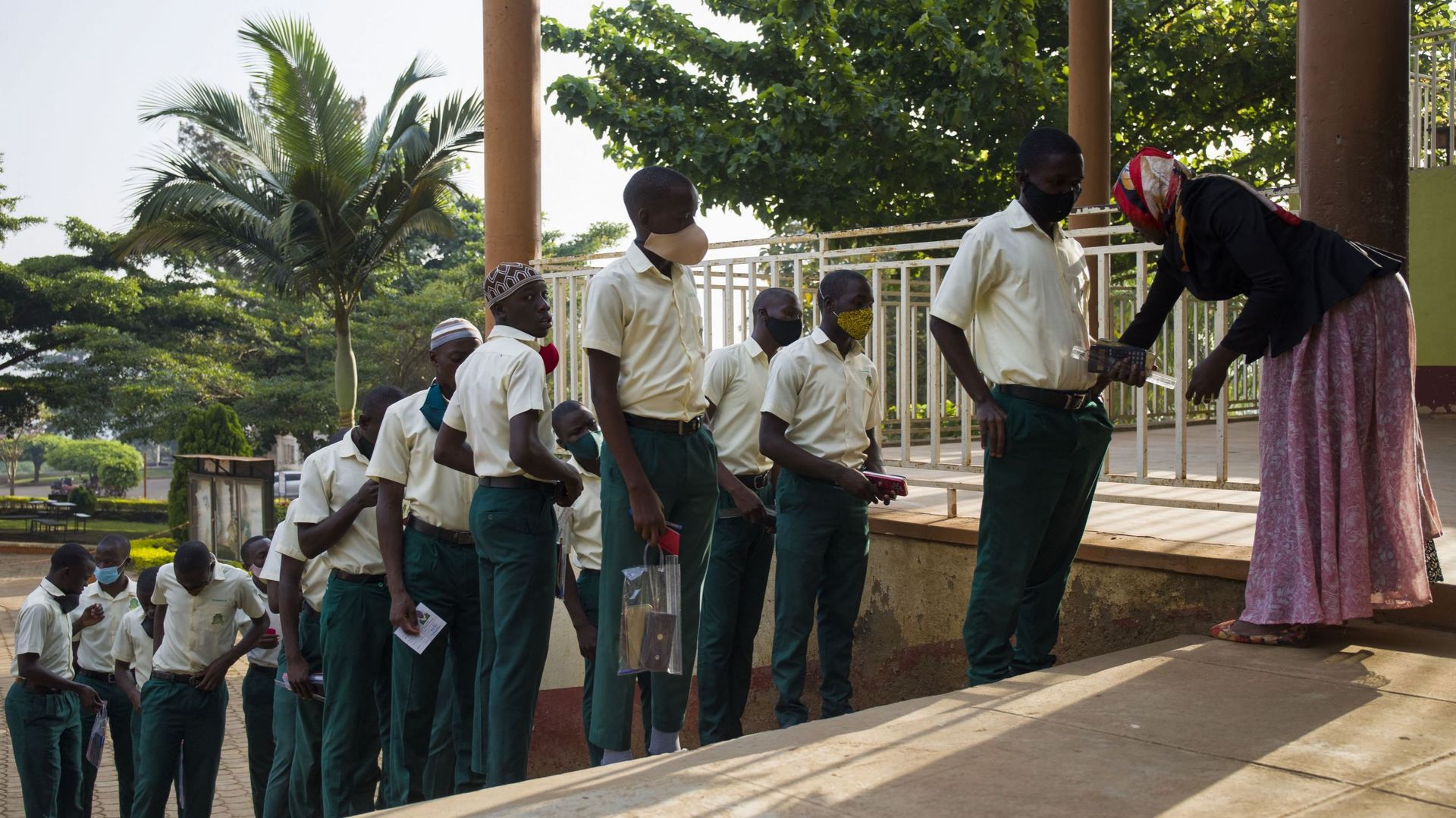 Des élèves de quatrième année de l’école secondaire mixte Mbogo font la queue pour l’inspection avant leurs examens finaux à Wakiso, le 1er mars 2021. Les élèves ont commencé leurs examens de fin d’année après que l’Ouganda a fermé toutes les écoles en ma