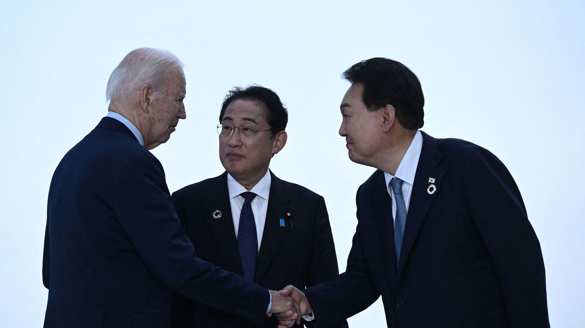 De gauche à droite : le président américain Joe Biden, le premier ministre japonais Fumio Kishida et le président sud-coréen Yoon Suk Yeol se saluent avant une réunion trilatérale lors du sommet des dirigeants du G7 à Hiroshima, le 21 mai 2023.
