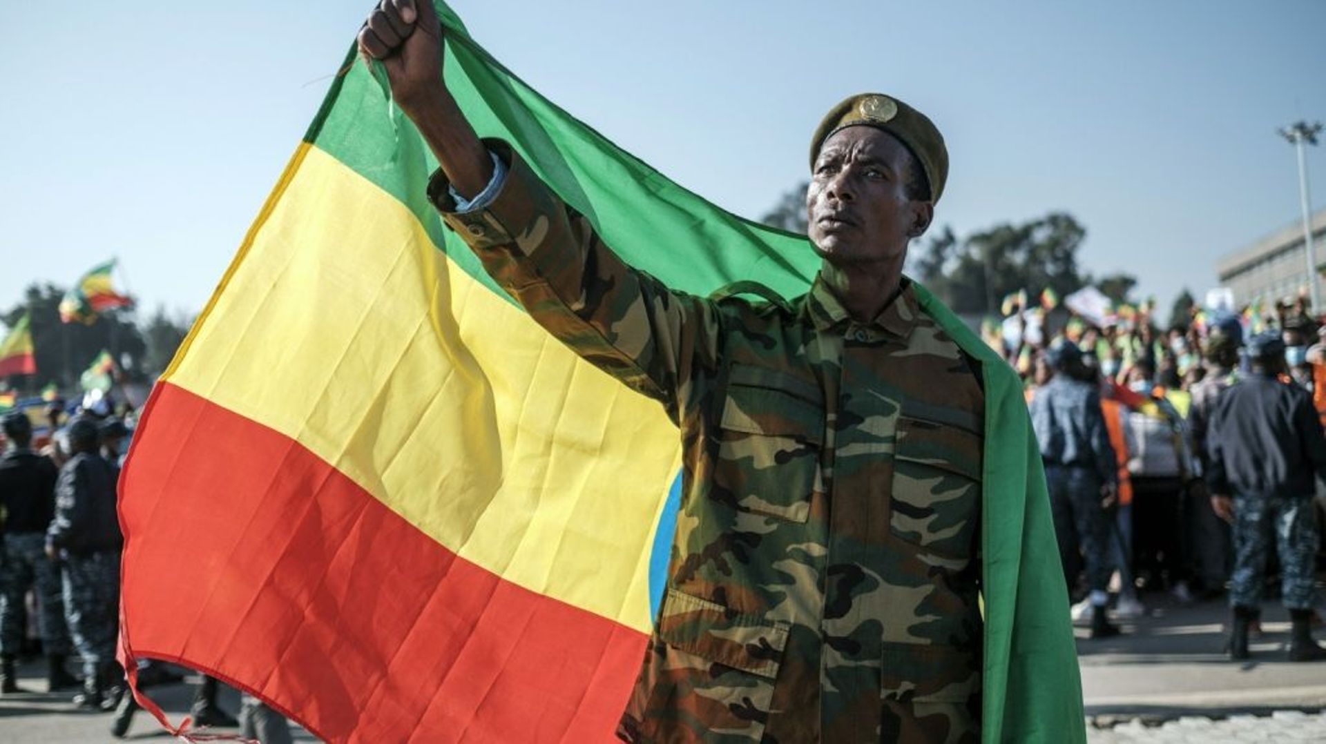 Un homme en treillis tient le drapeau éthiopien lors d’un rassemblement progouvernemental à Addis Abeba, le 7 novembre 2021.