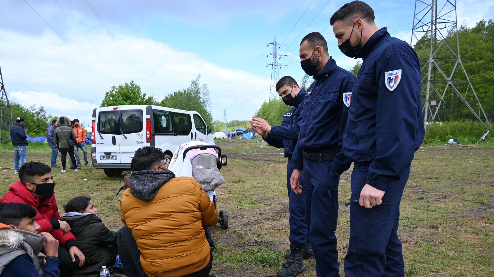 Image de policiers face à des migrants dans un camp à Calais