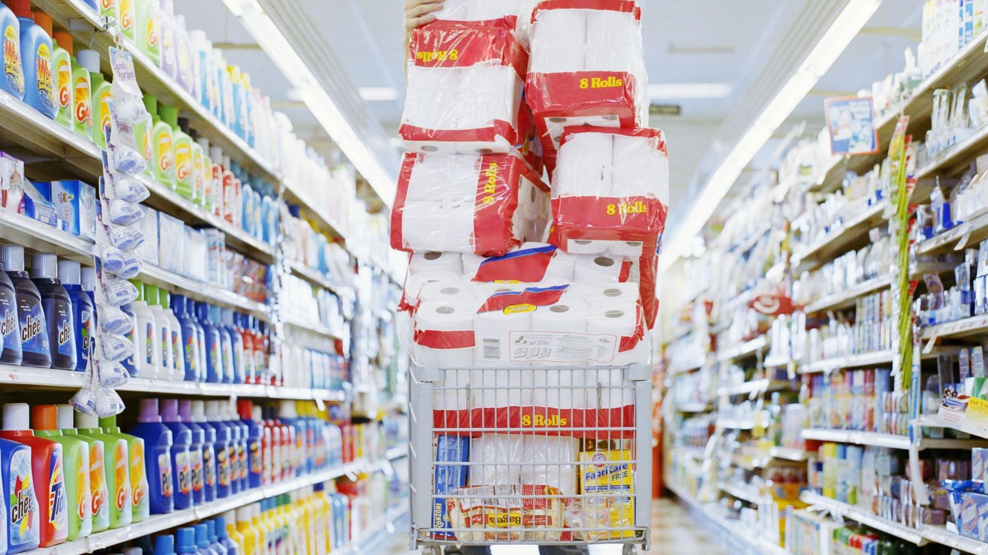 Man with cart stacked with grocery