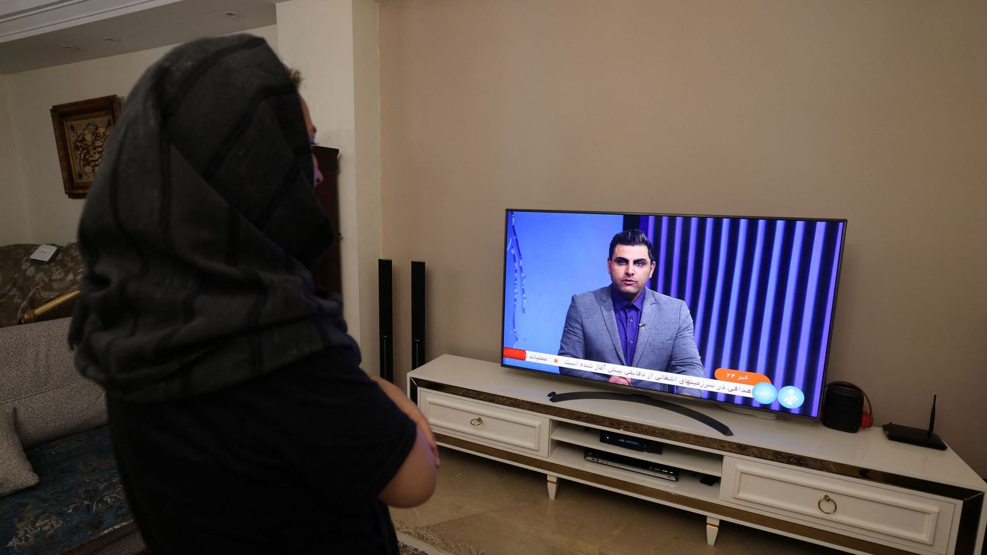 Une femme iranienne à Téhéran regarde une chaîne de télévision d’information iranienne qui couvre l’attaque de l’Iran contre Israël, le 14 avril 2024.
