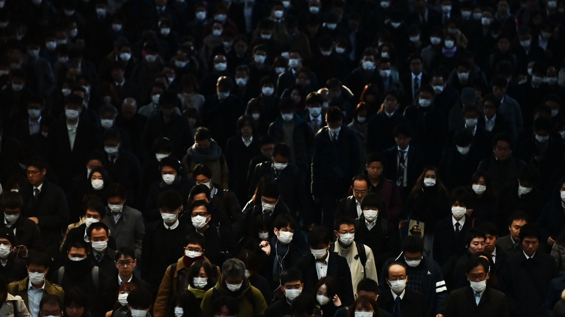 Les navetteurs vêtus de masques se rendent au travail pendant l'heure de pointe du matin à la gare de Shinagawa à Tokyo le 28 février 2020. Le 28 février, le Premier ministre japonais a défendu son appel aux écoles du pays pour fermer le nouveau coronavir