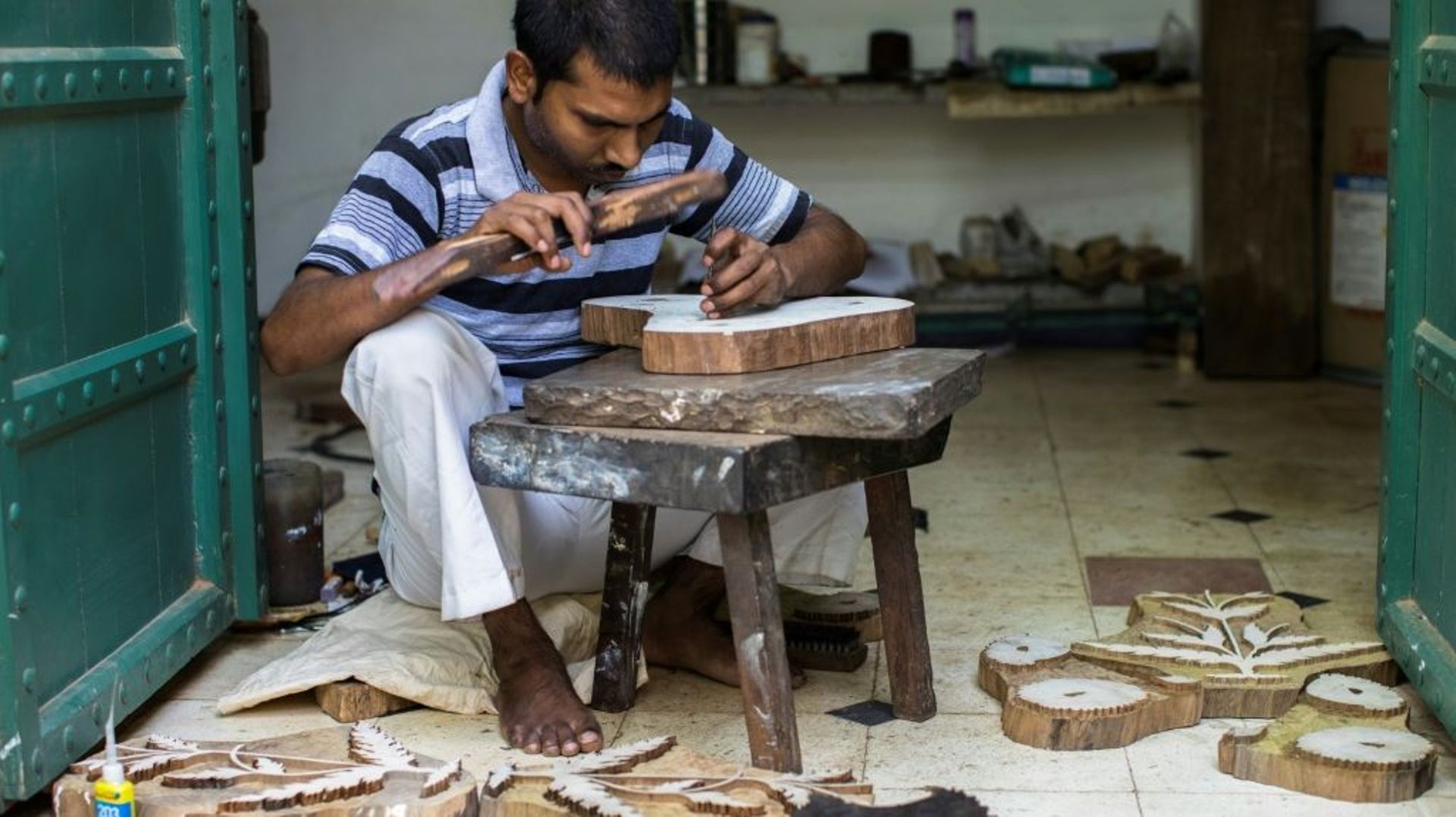 Un sculpteur grave des motifs d'impression sur des planches en bois dans l'atelier de la créatrice Brigitte Singh, le 2 juin 2022 à Amber, dans l'Etat du Rajasthan, en Inde.
