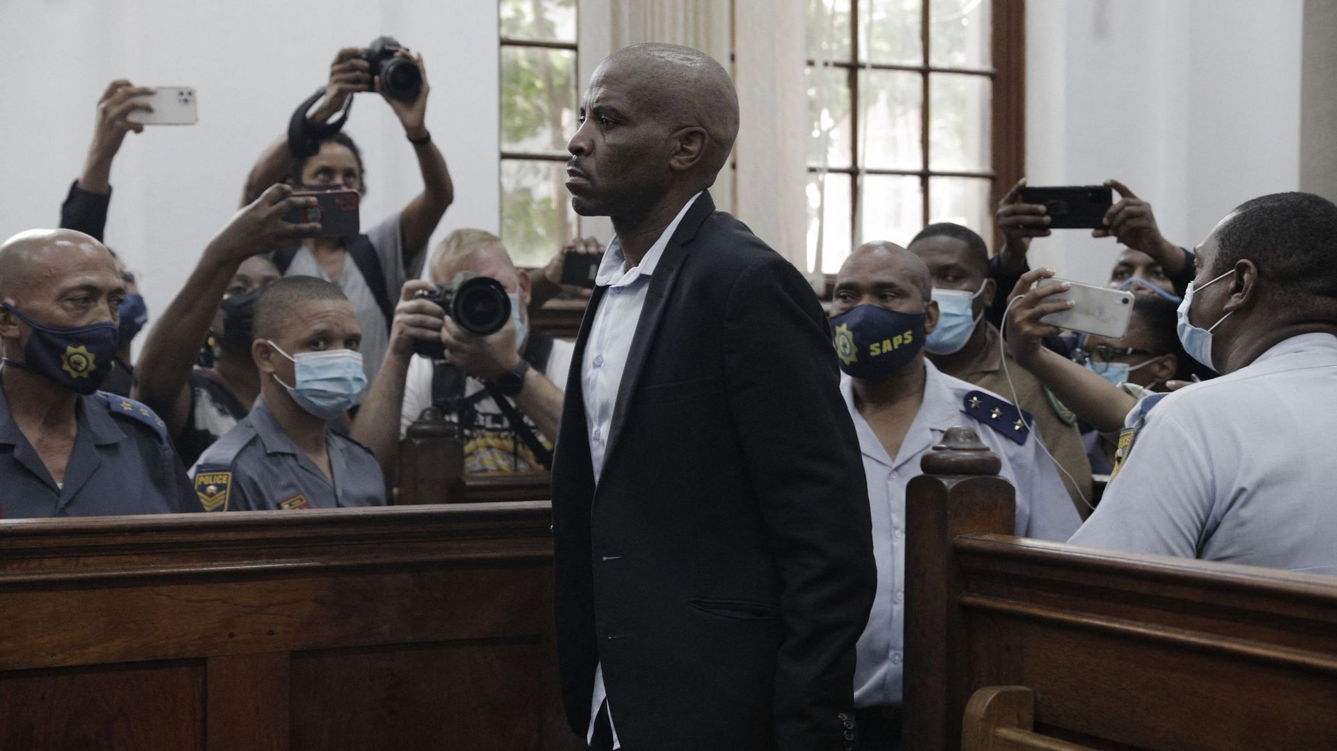 Zandile Christmas Mafe (C), un suspect lié à l'incendie du Parlement sud-africain, comparaît devant le tribunal de première instance du Cap, le 11 janvier 2022.