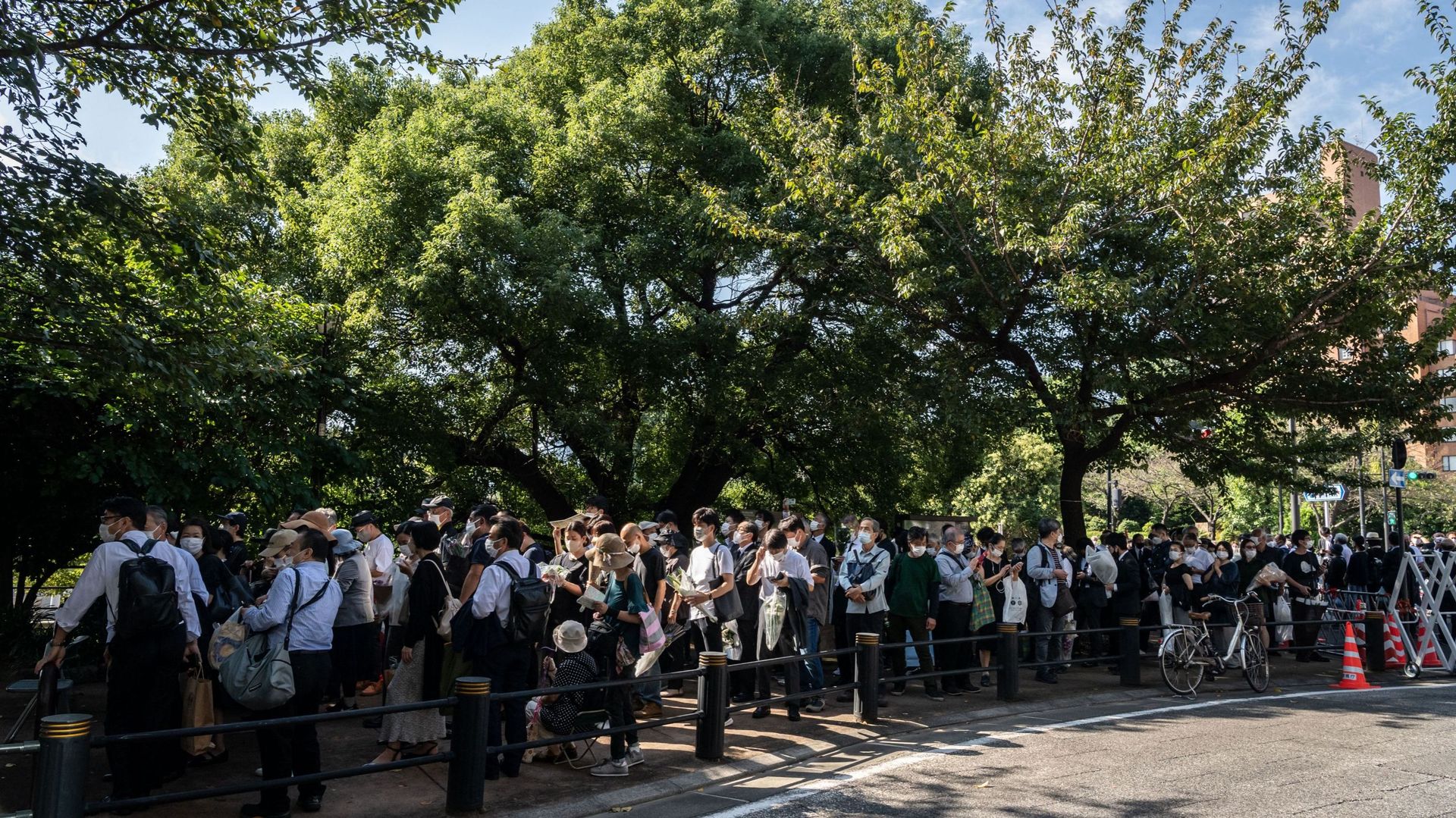 Les gens font la queue dans une rue près du Nippon Budokan pour déposer des fleurs avant les funérailles nationales de l'ancien Premier ministre japonais Shinzo Abe, à Tokyo, le 27 septembre 2022.