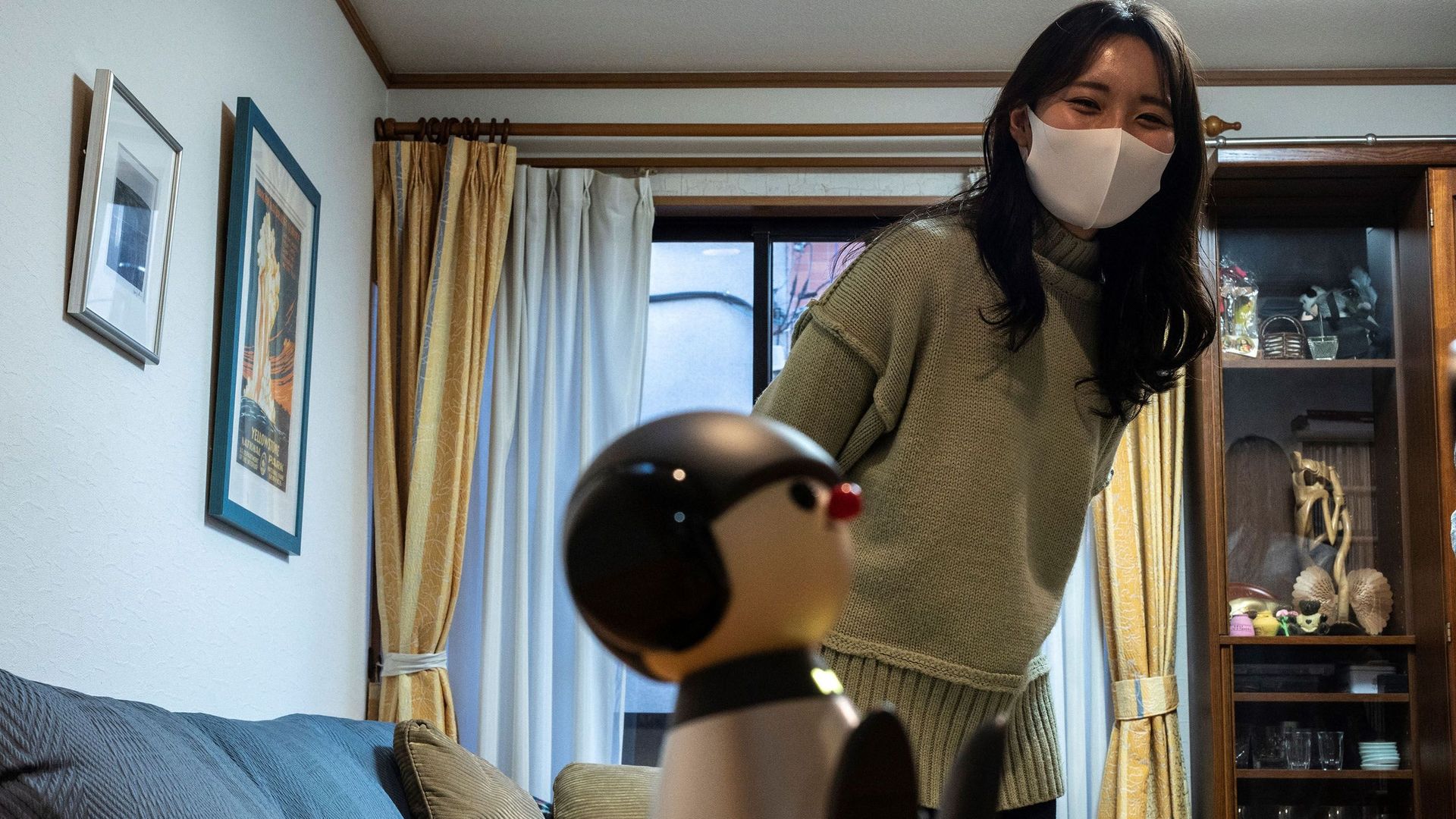 Nami Hamaura adopté Charlie, un robot de la taille d'un mug doté d'une intelligence artificielle, avec une tête ronde, un nez rouge et un noeud papillon clignotant, qui communique avec son propriétaire en chantant.