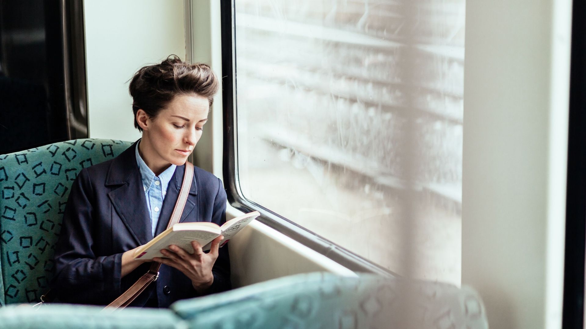Femme lisant un livre dans un train.