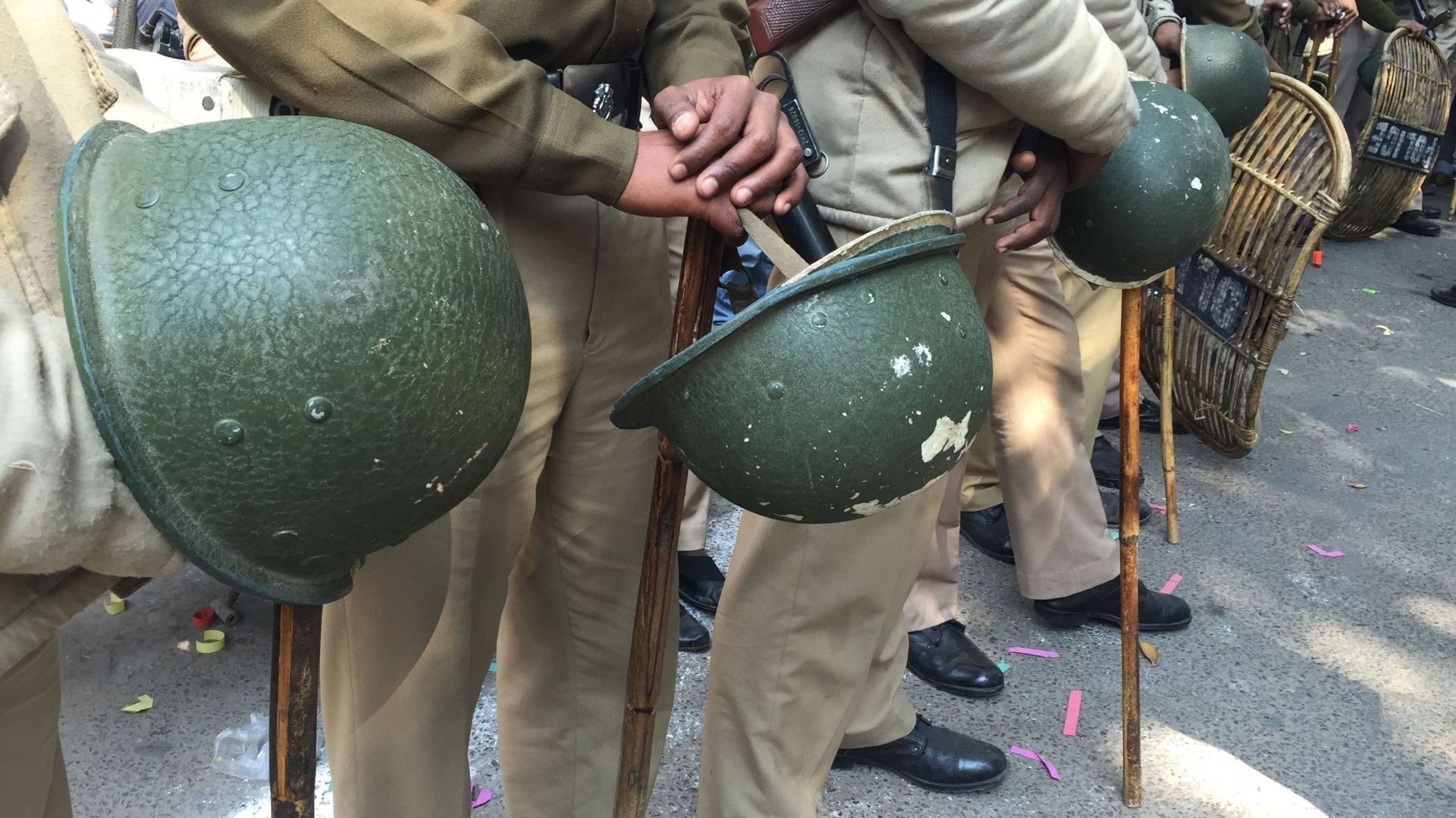 Image d'illustration : policiers indiens tenant leur casque dans la rue