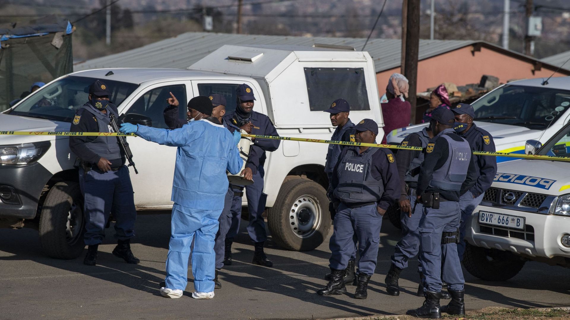 Des membres de la police sud-africaine (SAPS) et du service de médecine légale inspectent la scène d'une fusillade de masse à Soweto, en Afrique du Sud, le 10 juillet 2022. 