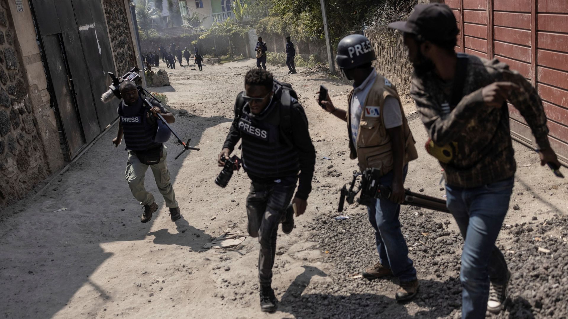 Des membres des médias courent pour s'abriter alors que la police disperse des manifestants lors d'une manifestation contre la Force régionale de la Communauté d'Afrique de l'Est (EACRF) à Goma, dans l'est de la République démocratique du Congo, le 18 jan