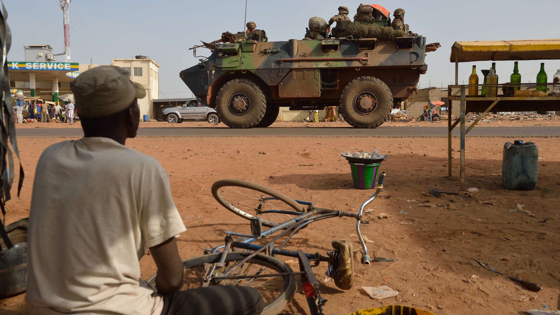 Un réparateur de bicyclettes observe le passage des militaires français à Ségou, jeudi