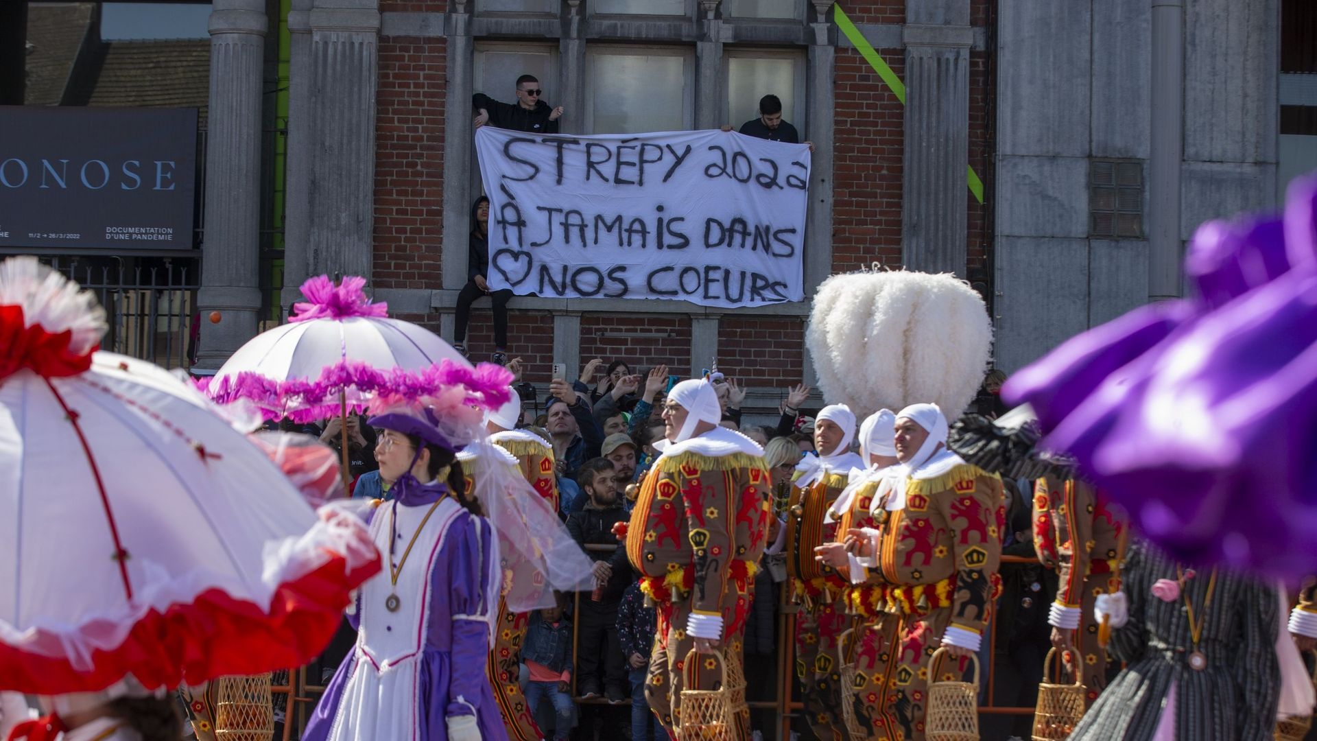 Des gens se rassemblent pour une minute de silence en hommage aux victimes de l’accident de dimanche dernier impliquant un groupe de carnavaliers, lors des célébrations du carnaval de La Louvière, le dimanche 27 mars 2022 (illustration).