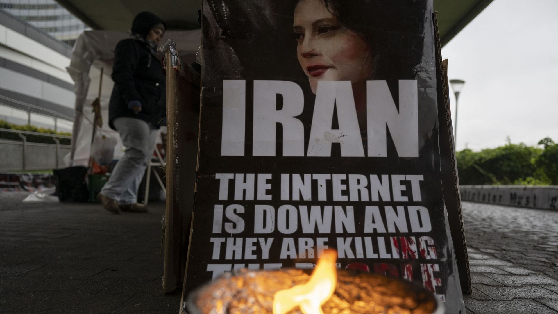 Sur une photo prise le 16 novembre 2022, une pancarte et des manifestants de l'opposition iranienne se tiennent à l'extérieur du bâtiment pendant la réunion du Conseil des gouverneurs de l'Agence internationale de l'énergie atomique (AIEA) au siège de l'a