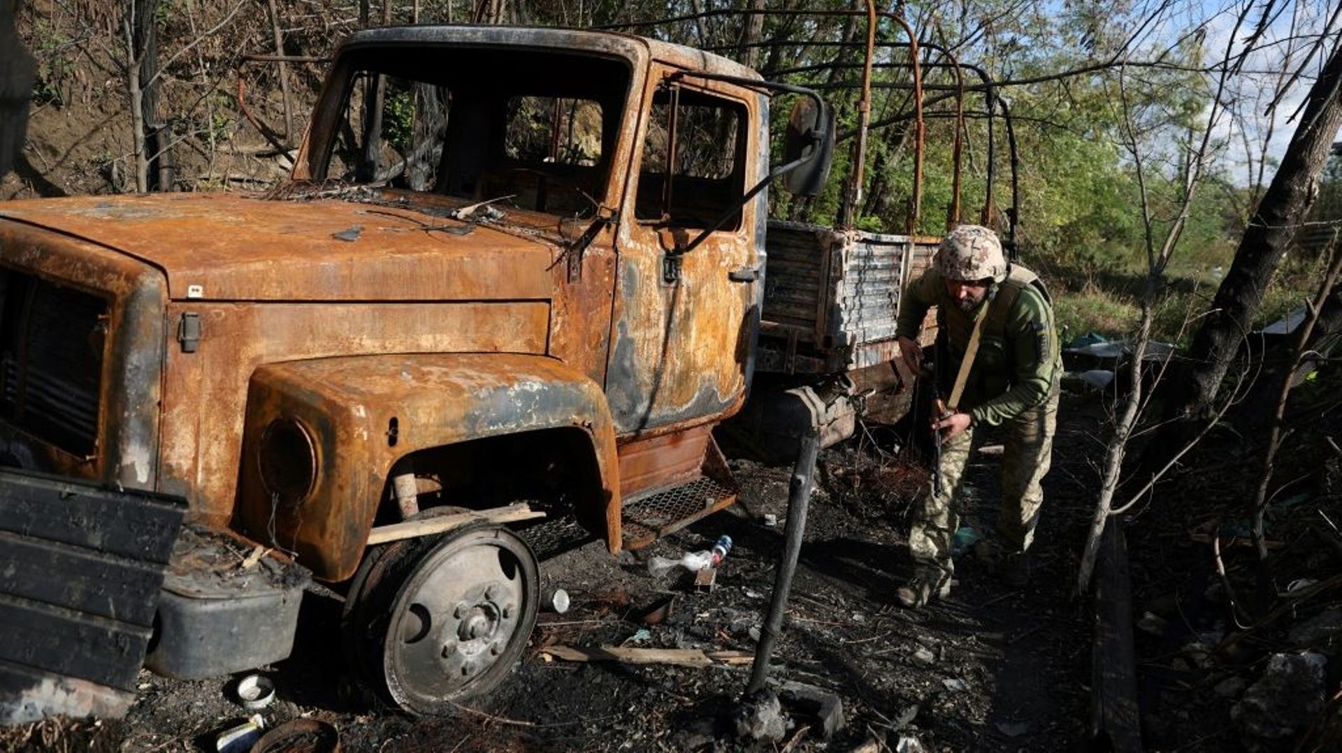Un soldat ukrainien marche près d’un véhicule brûlé sur la ligne de front face aux troupes russes dans la région de Donetsk, dans l’est de l’Ukraine, le 23 septembre 2022