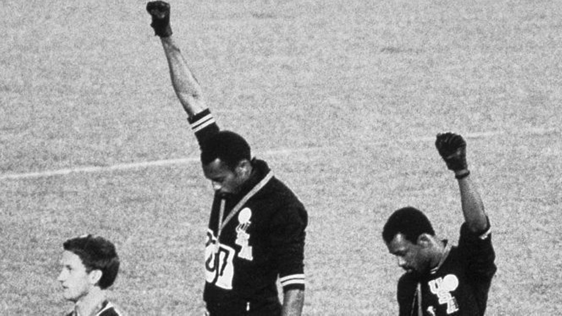 Tommie Smith et John Carlos se partagent une paire de gants pour lever leur poing en guise de protestation face à la ségrégation raciale aux États-Unis.