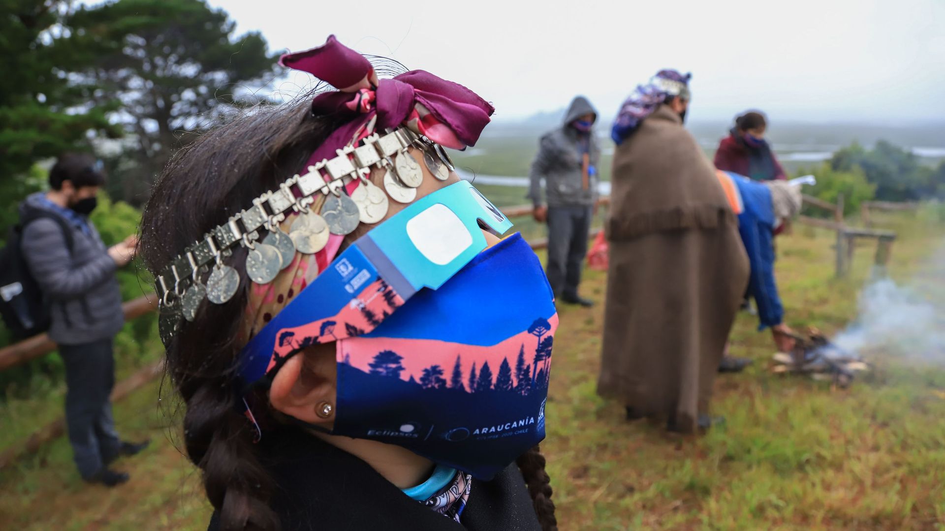 Une famille indigène mapuche regarde l'éclipse totale de soleil à Carahue, région de l'Araucanie au sud du Chili, le 14 décembre 2020. Une éclipse solaire qui a duré environ deux minutes a plongé le sud du Chili et de l'Argentine dans l'obscurité lundi