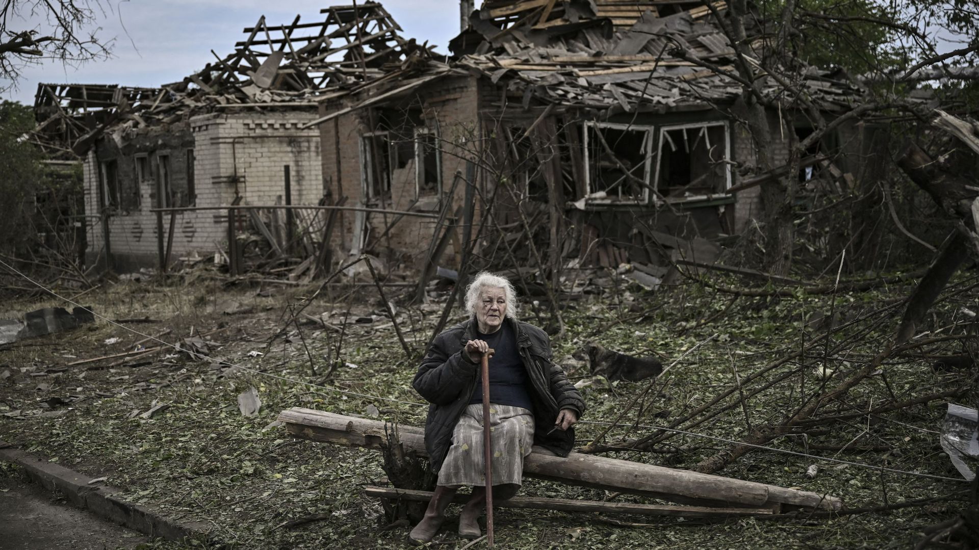 Une femme âgée est assise devant des maisons détruites après une frappe de missile, qui a tué une vieille femme, dans la ville de Druzhkivka (également écrite Druzhkovka) dans la région de Donbas, dans l'est de l'Ukraine, le 5 juin 2022.  