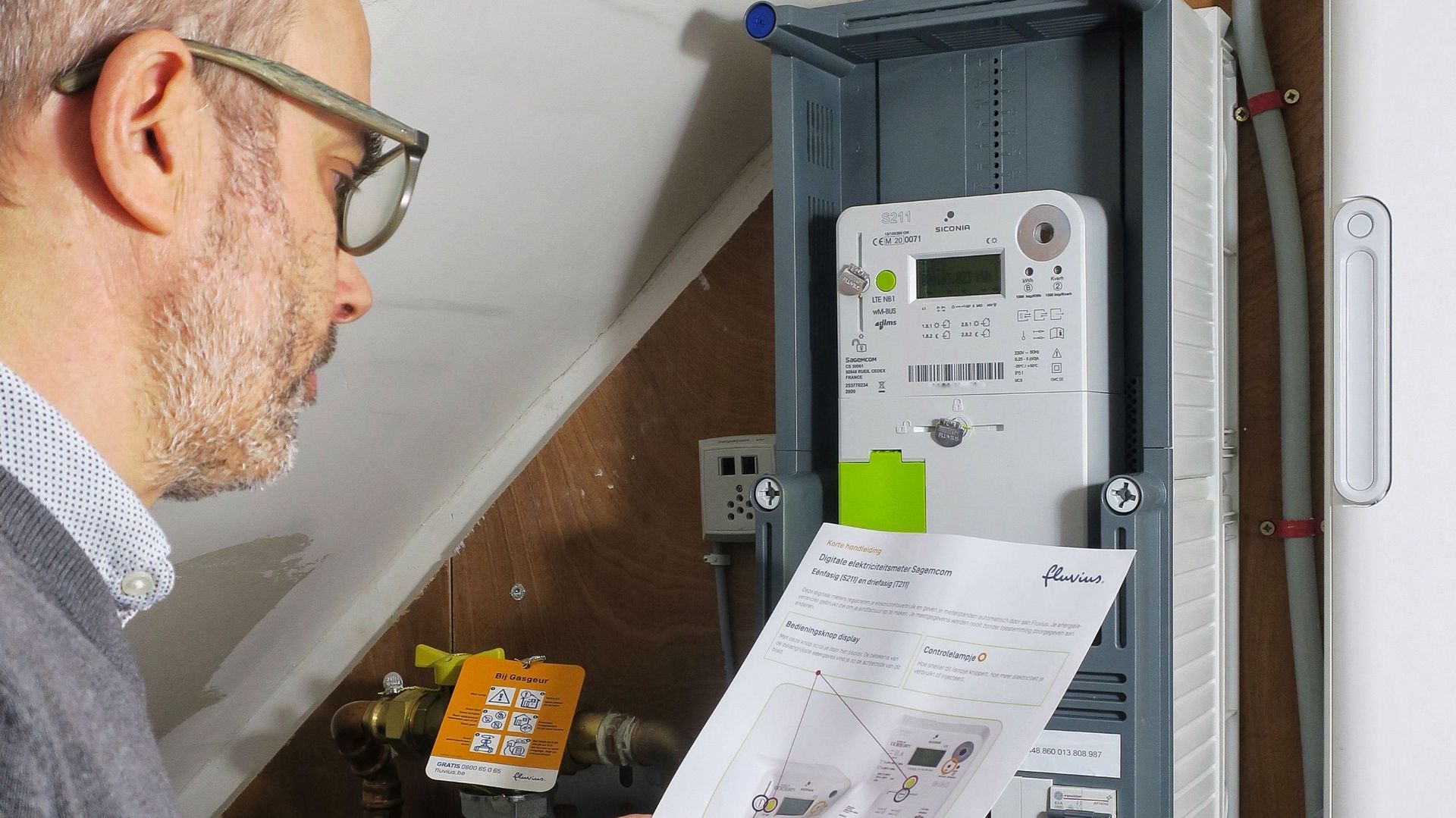 Une photo d'illustration montre un homme inspectant son compteur électrique intelligent Sagemcom à Gand, le jeudi 14 janvier 2021.
