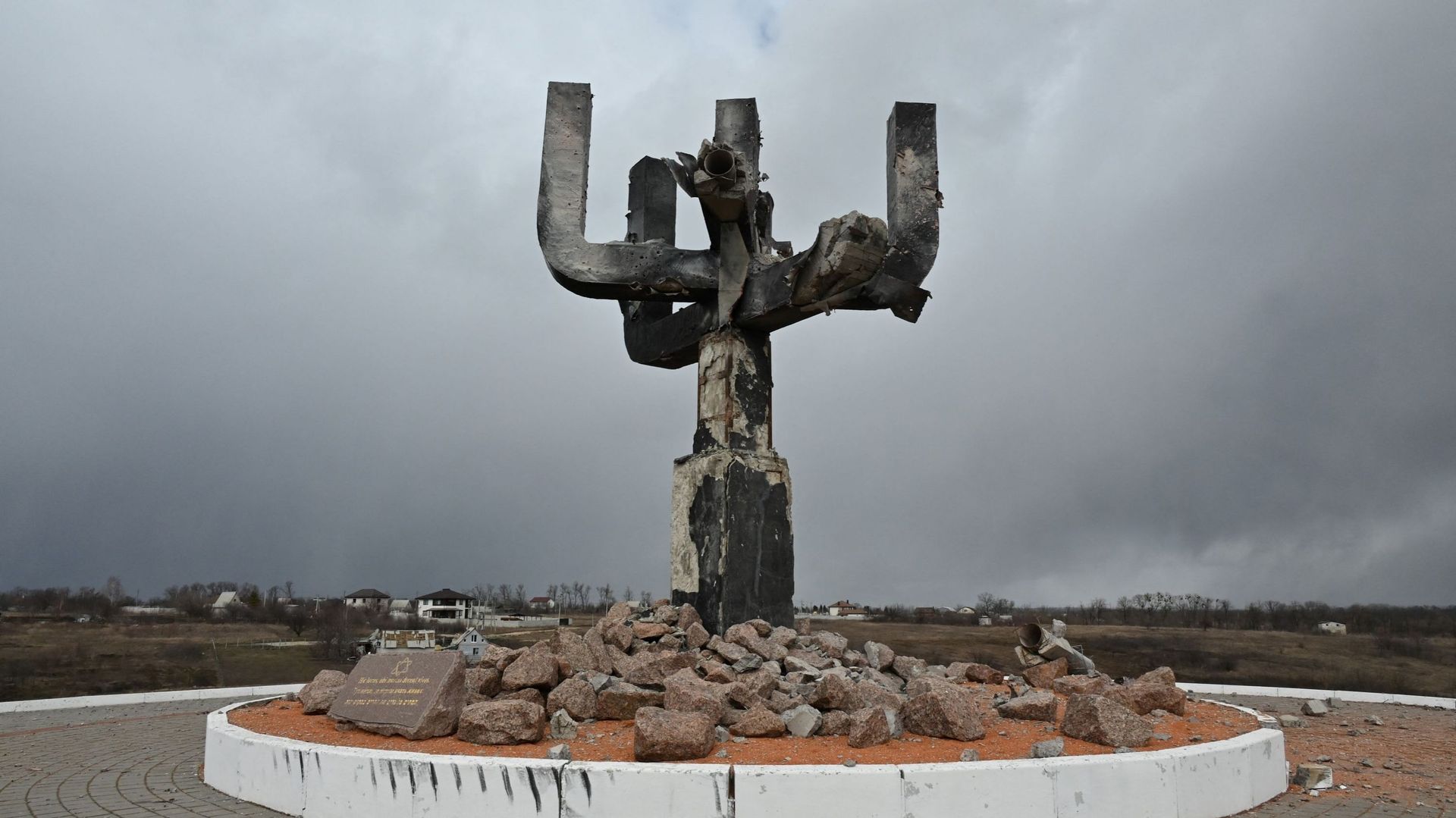 Une photo prise le 27 mars 2022 montre une vue du mémorial de la Menorah, érigé sur le lieu d’un massacre de Juifs par les nazis pendant la Seconde Guerre mondiale, un jour après qu’il ait été endommagé par un bombardement russe, à l’entrée du complexe co