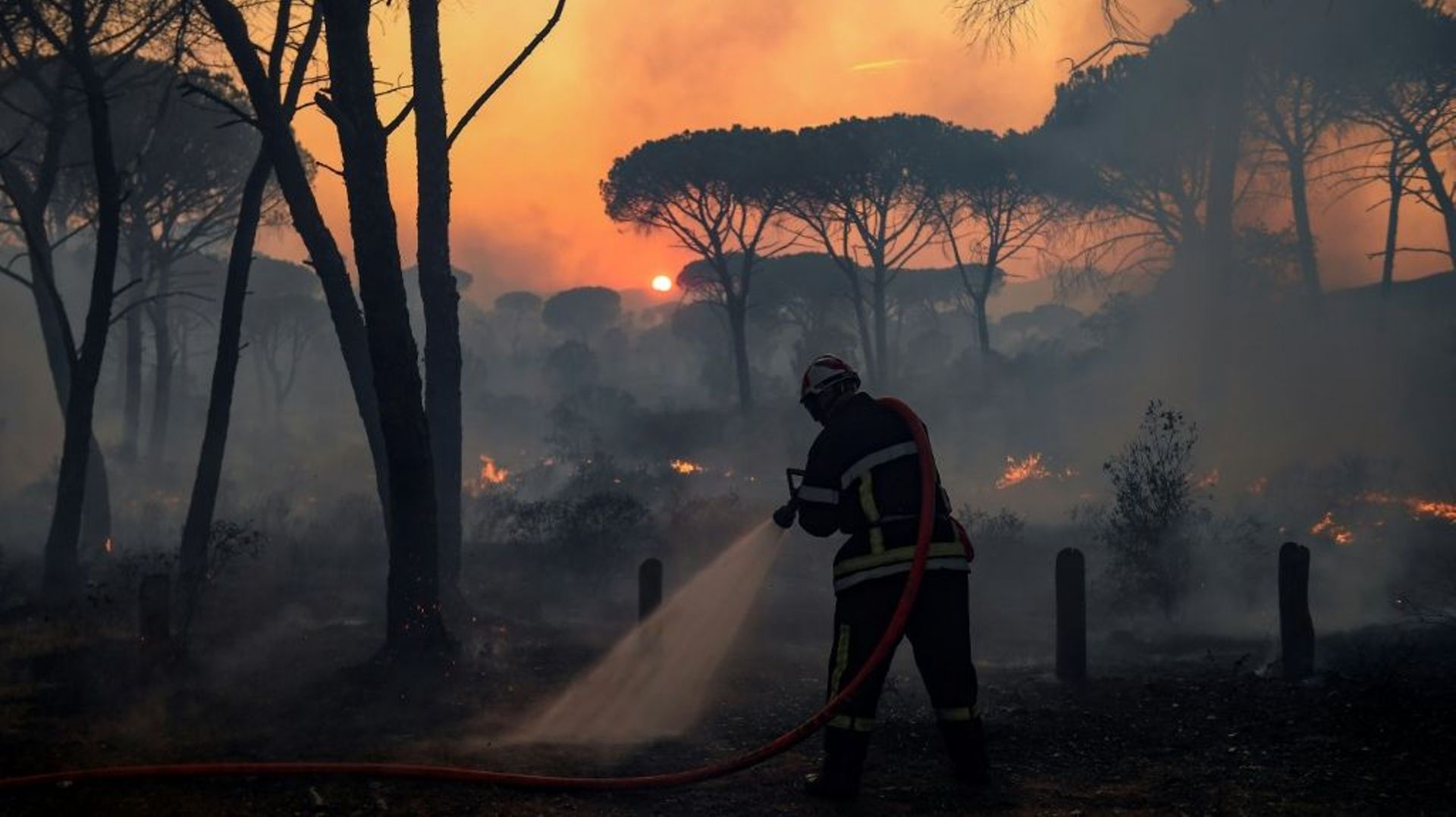 Un pompier français utilise une lance d'incendie lors d'un feu de forêt dans le département du Var, dans le sud de la France, le 17 août 2021