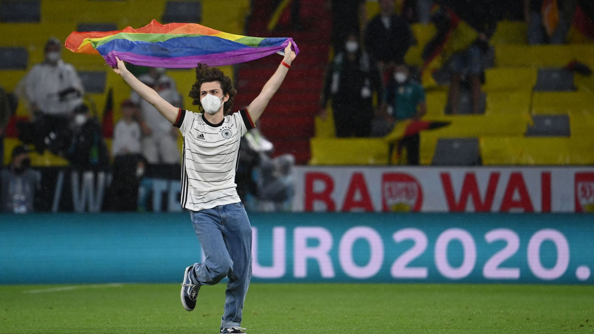 Un homme court avec un drapeau arc-en-ciel pendant le match Allemagne-Hongrie.