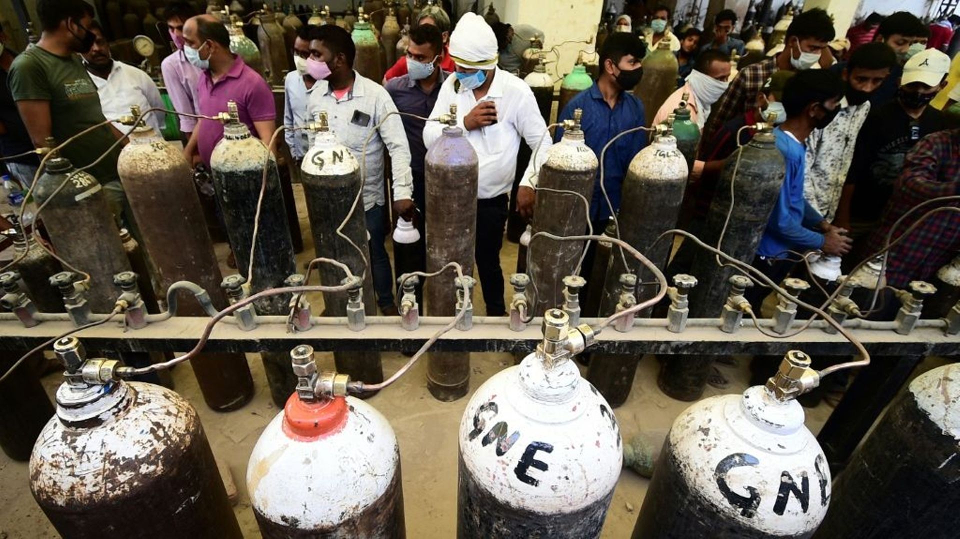 Des personnes font la queue pour remplir des bouteilles d'oxygène, le 20 avril 2021 à Allahabad, en Inde