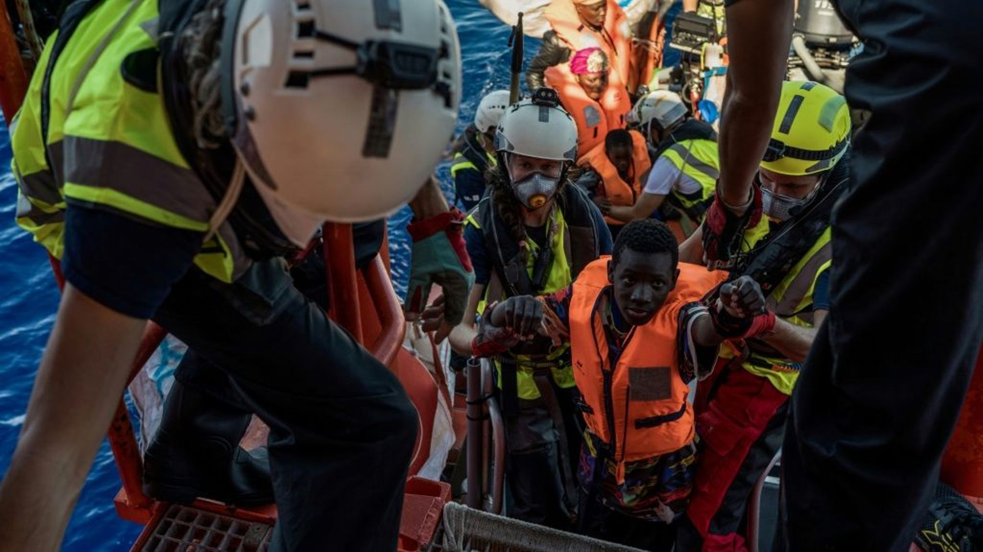 Des migrants montent à bord de l'Ocean Viking, navire de l'ONG "SOS Méditerranée", le 25 octobre 2022 au large de la Libye