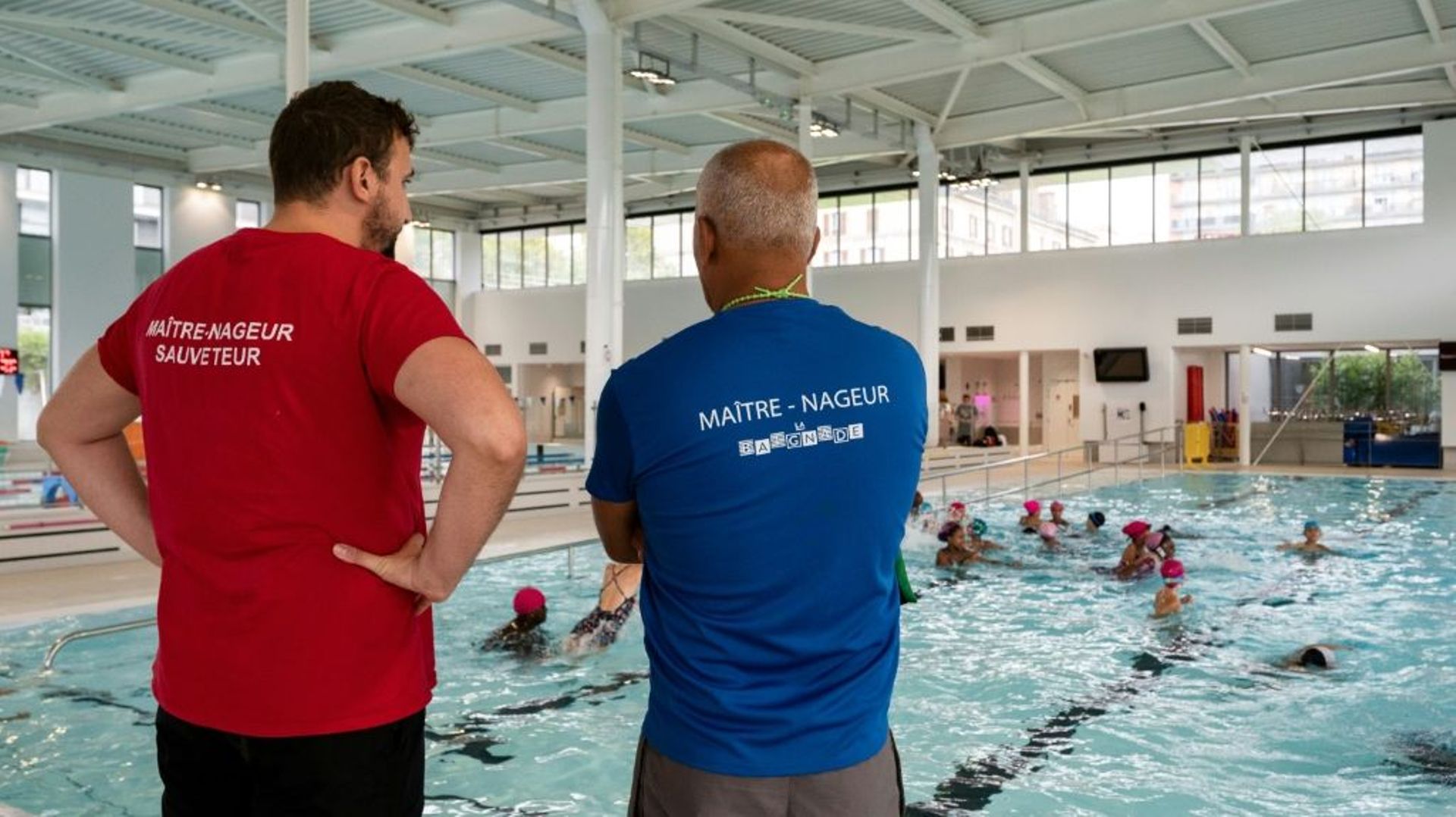 Des maîtres-nageurs surveillent le bassin de la piscine écologique Yvonne-Godard, le 9 septembre 2022 à Paris.