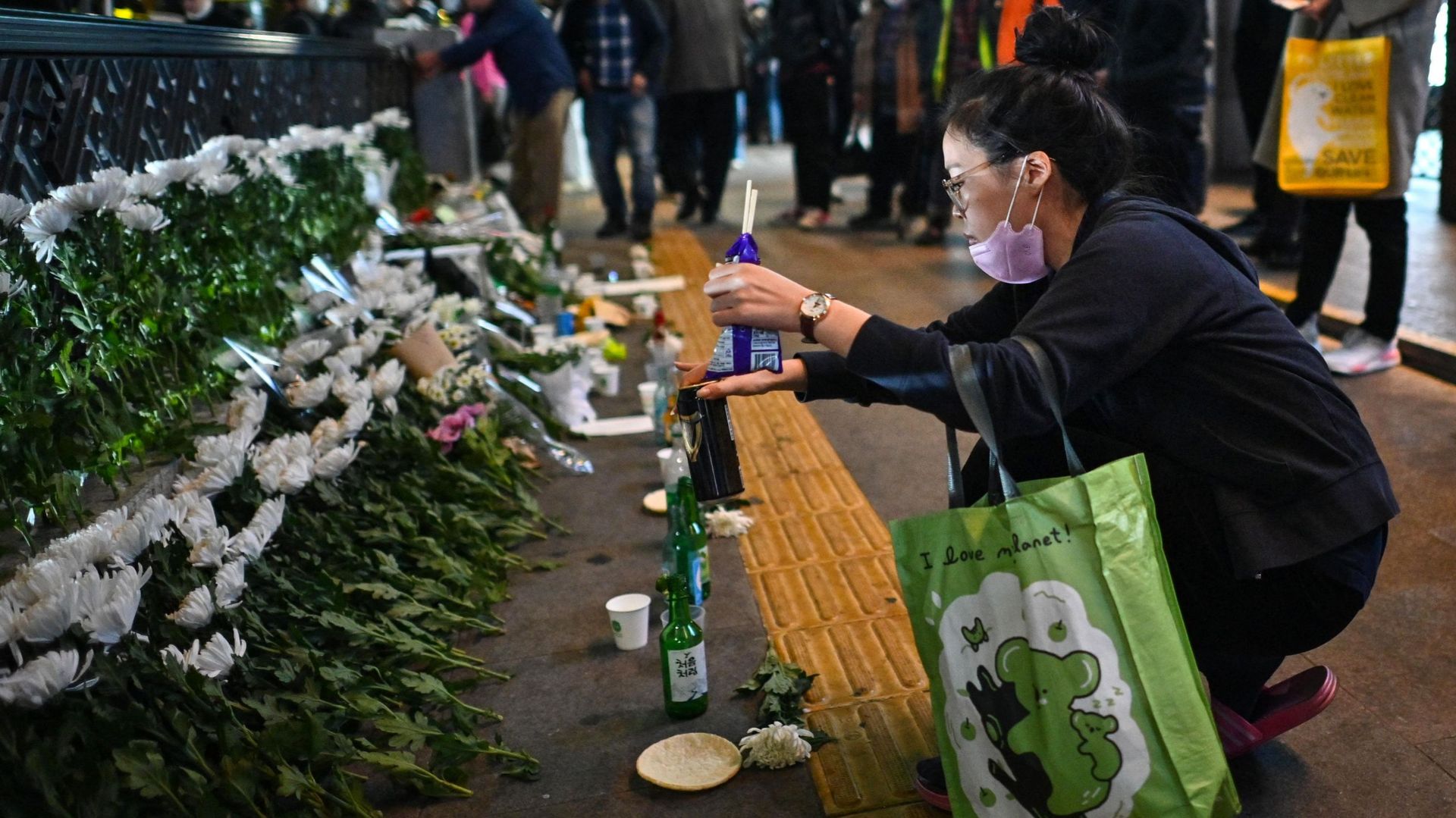 Une femme fait une offrande, en hommage aux personnes tuées lors d'une bousculade d'Halloween le 29 octobre, dans le quartier d'Itaewon à Séoul le 30 octobre 2022. 